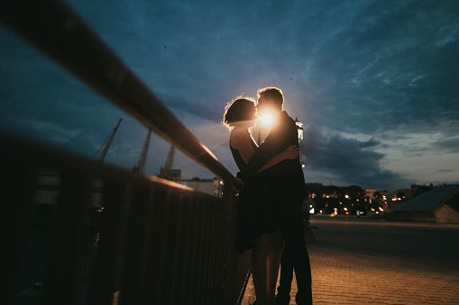 Photo of couple kissing near railing at night | Photo: Getty Images