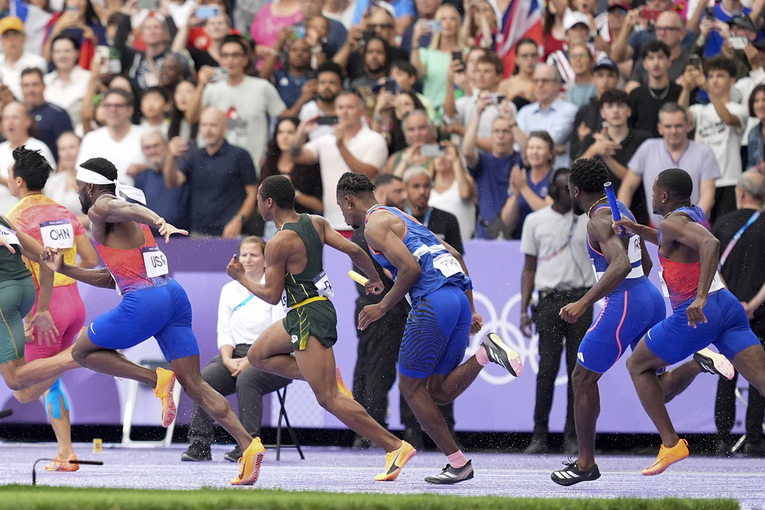 Christian Coleman attempting to pass the baton to Kenneth Bednarek during the Men's 4x100-meter Relay Final of the 2024 Summer Olympics on August 9, in France. | Source: Getty Images