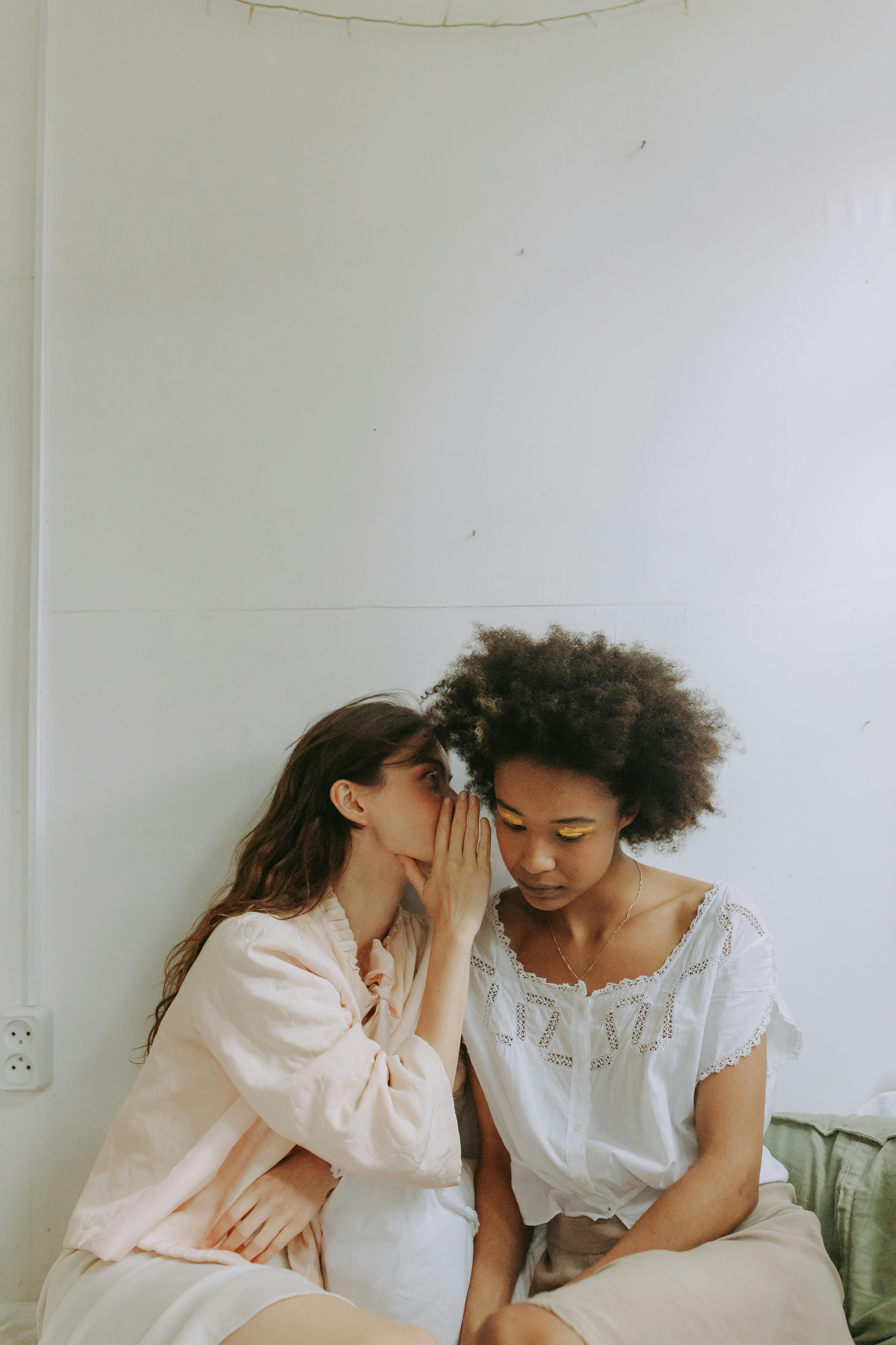 A woman telling another woman a secret | Source: Pexels