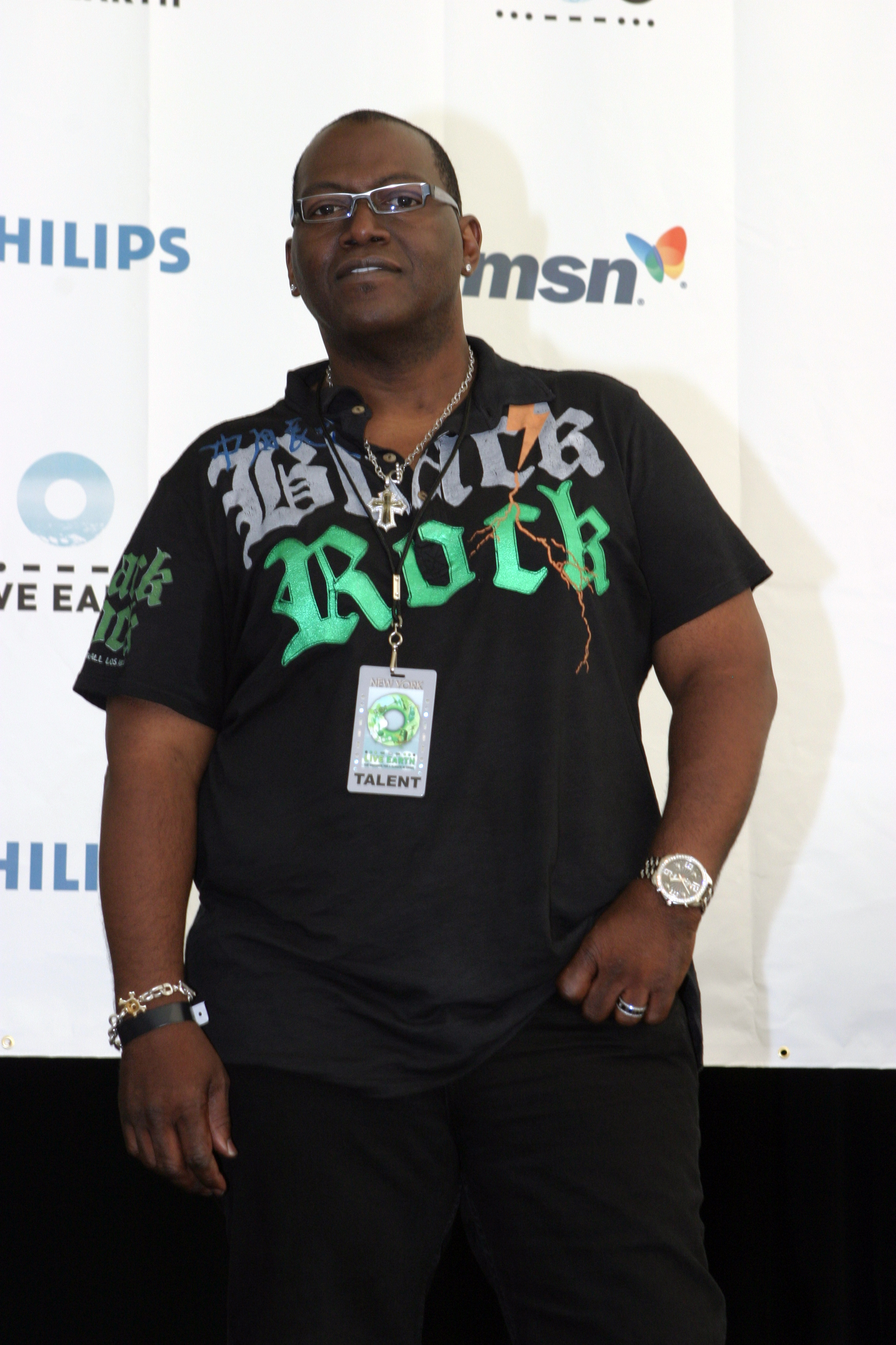 Randy Jackson keeps it casual in a graphic polo and layered jewelry while posing backstage at the climate-focused Live Earth event.