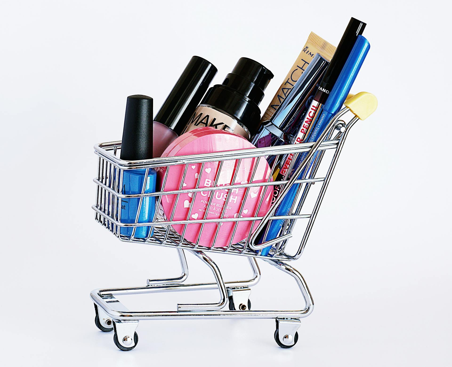 Makeup products in a mini shopping cart | Source: Pexels