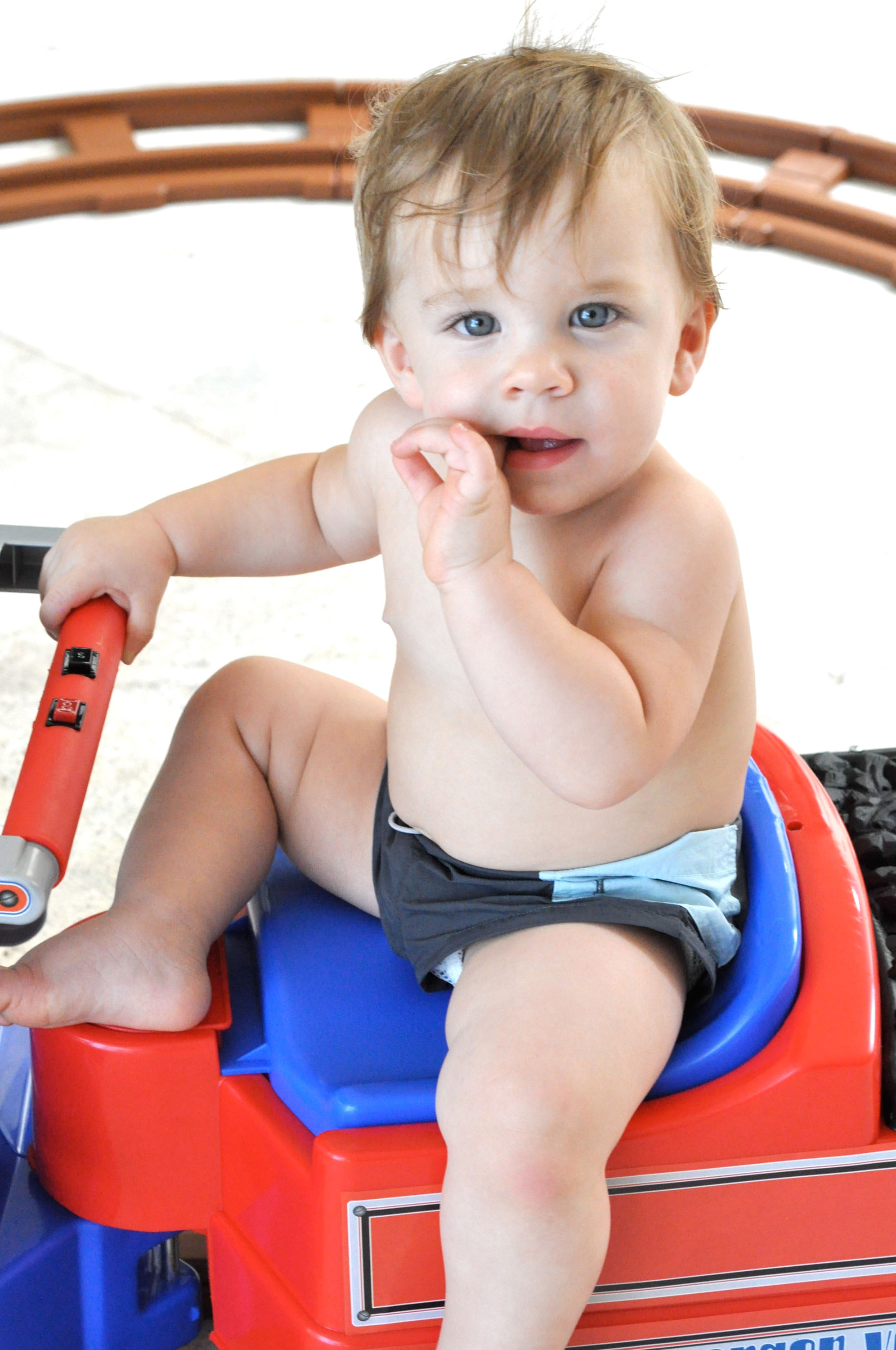 Matteo Martin sits on a bright red-and-blue toy vehicle in only a diaper, gazing at the camera in a handout photo shared by Ricky Martin in Miami, Florida.