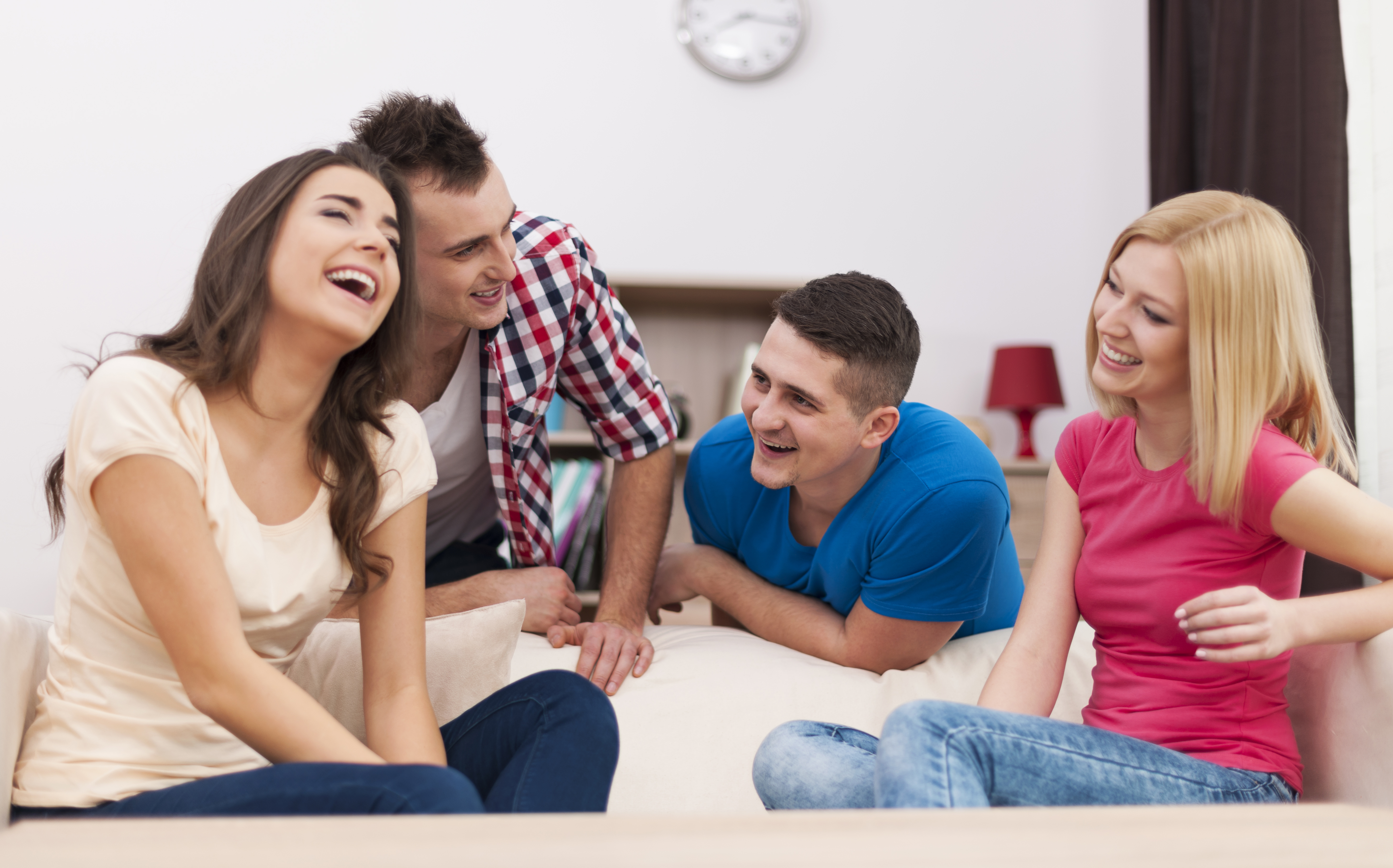 People laughing while sitting on the couch | Source: Freepik