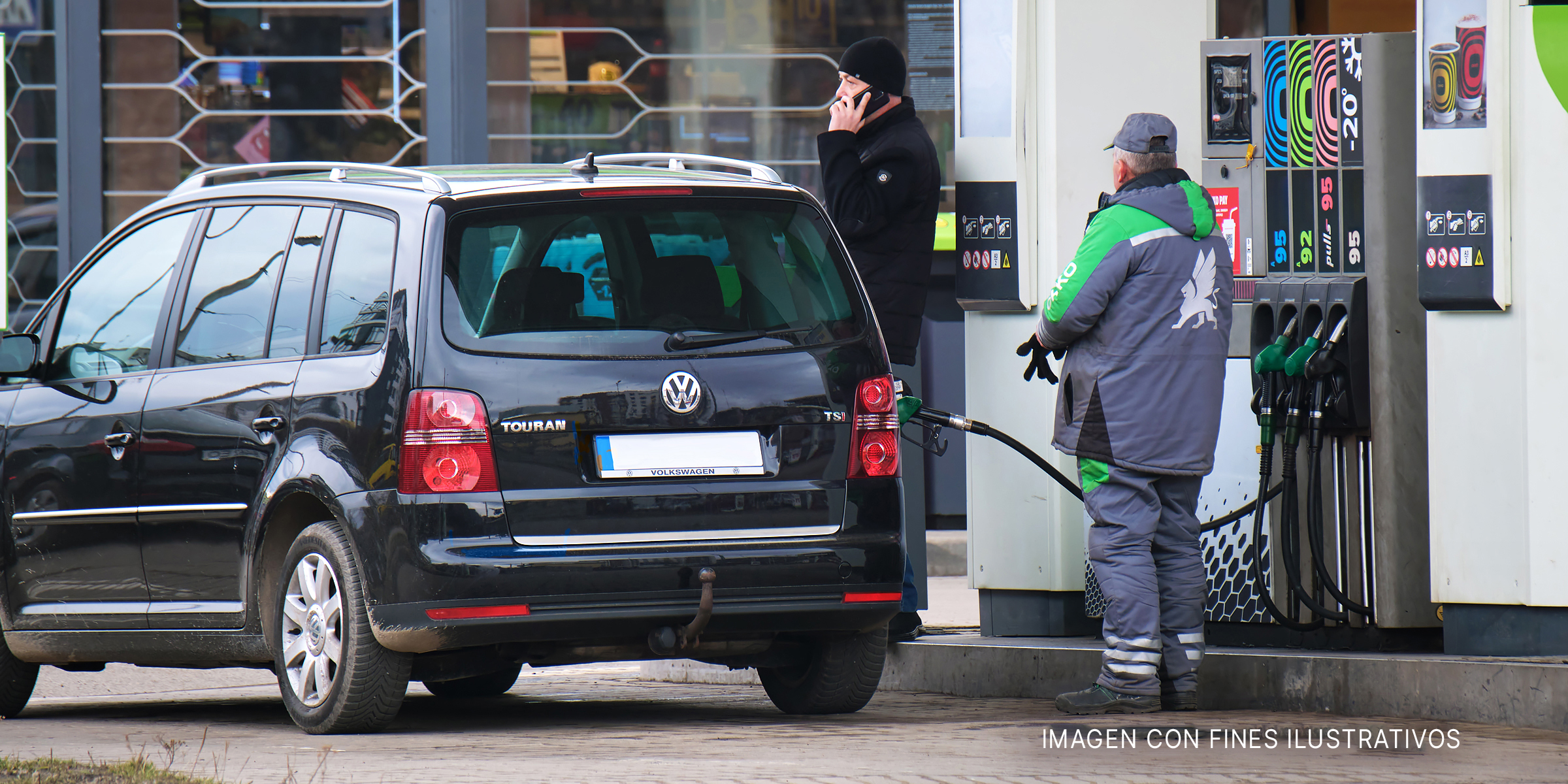 Trabajador de una estación de servicio llenando el tanque de gasolina de un auto negro. | Foto: Shutterstock