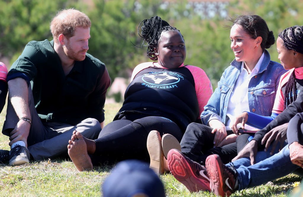 Prince Harry and Meghan join surf mentors and participate in a group activity as they visited Waves for Change, an NGO, at Monwabisi Beach. | Source: Getty Images