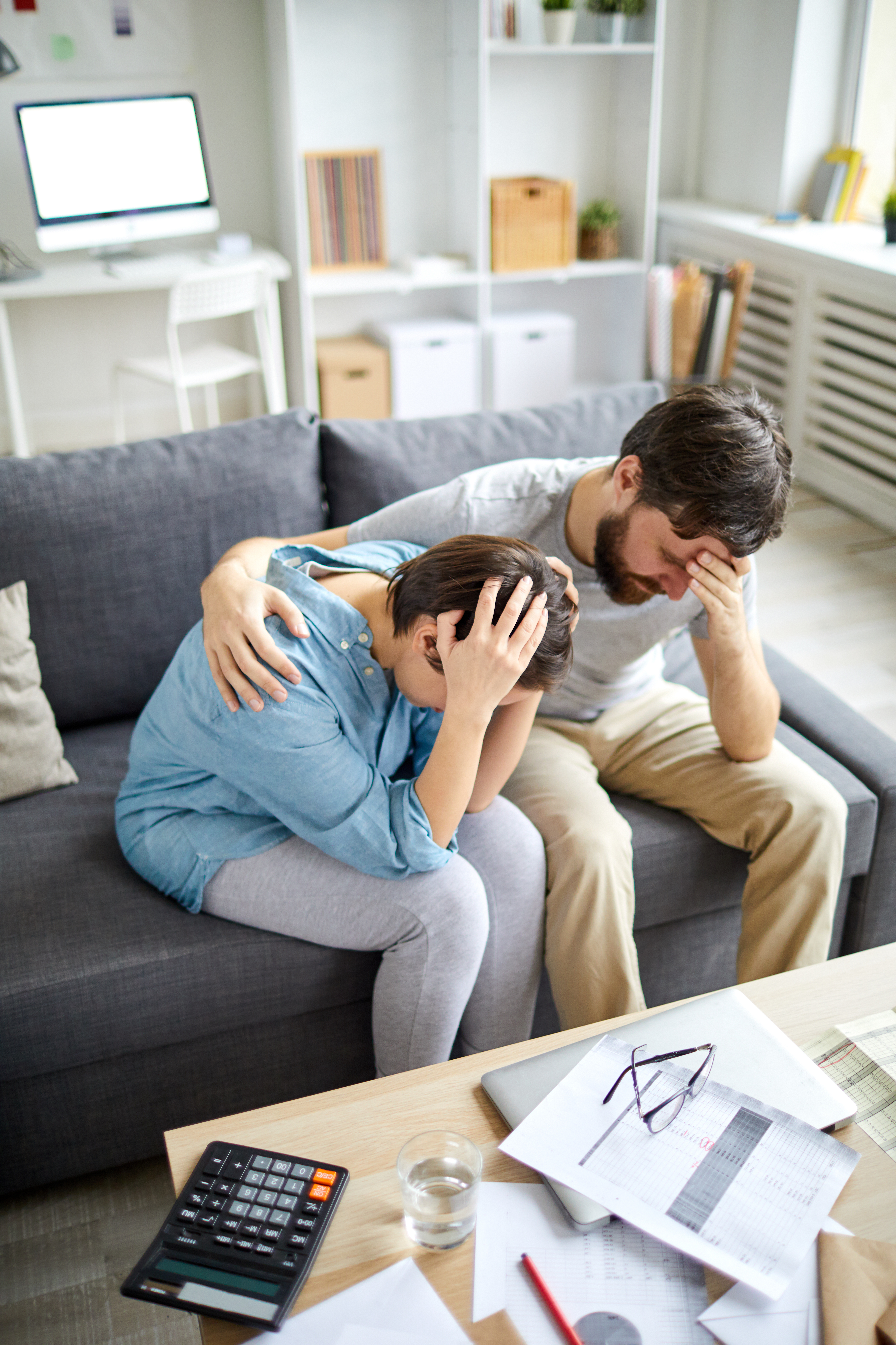 Un hombre angustiado rodea con su brazo a una mujer angustiada | Fuente: Shutterstock