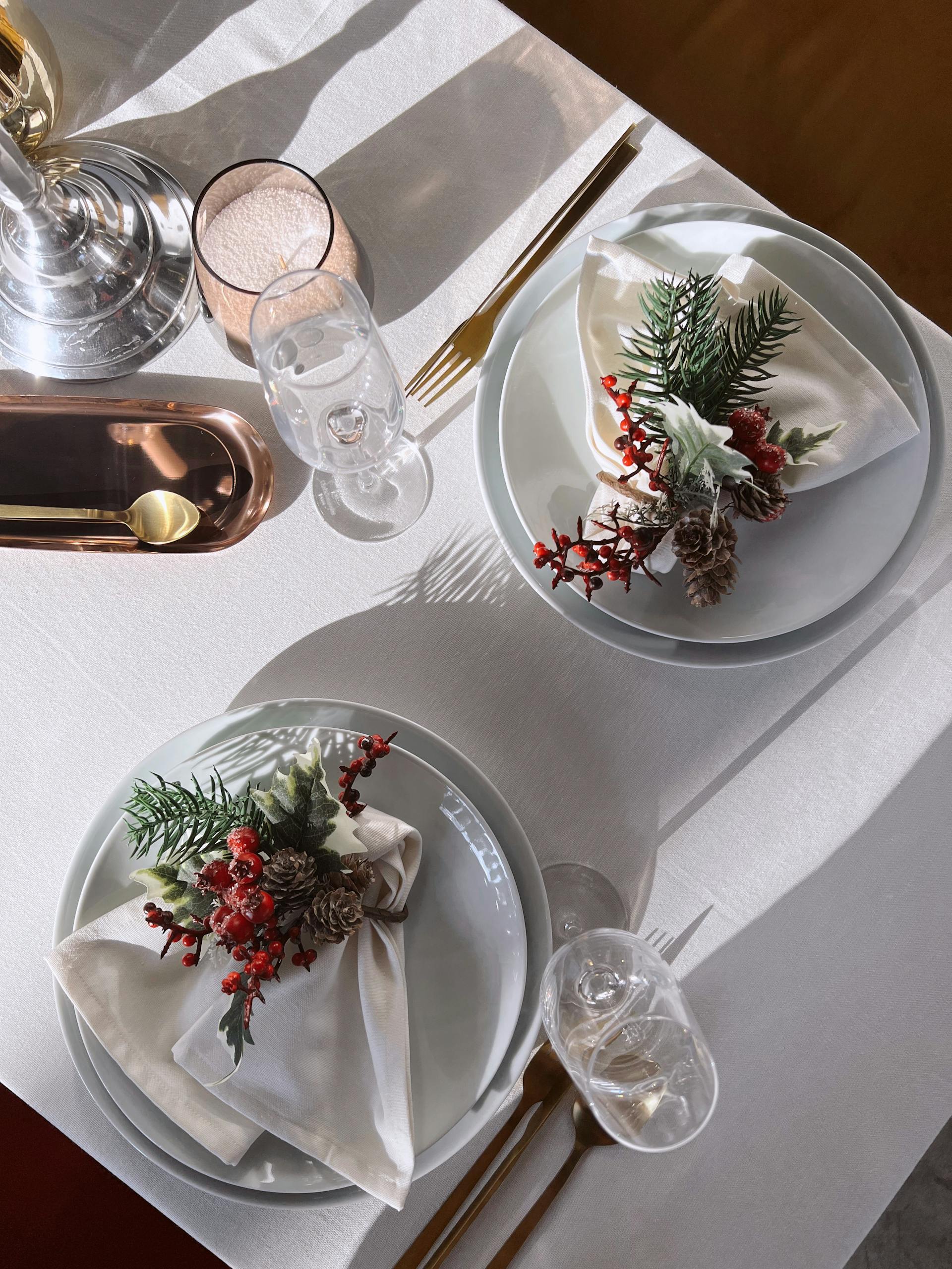 A set table with napkins decorated with pine twigs and cones | Source: Pexels