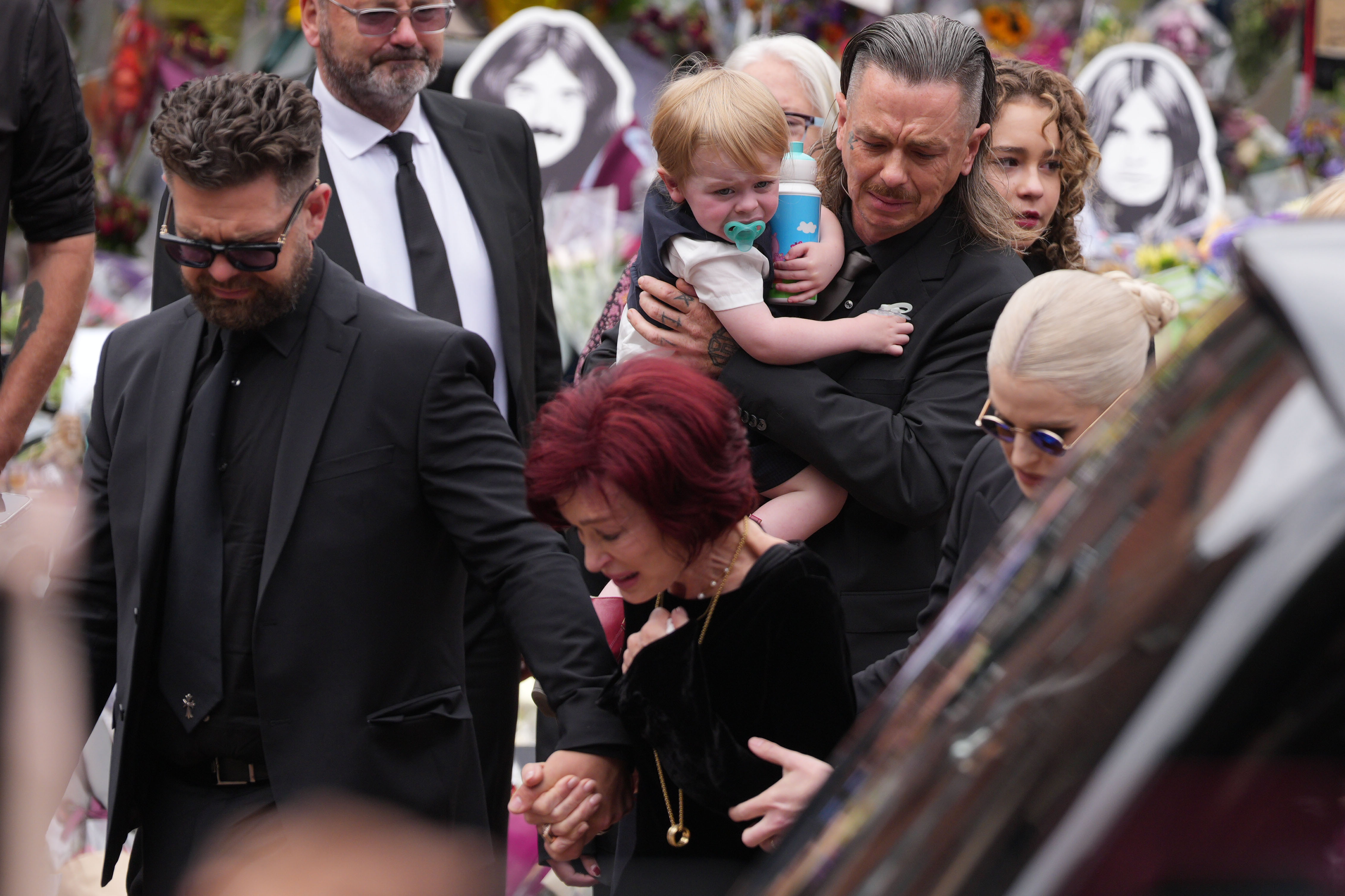 Jack, Sharon and Kelly Osbourne, with Sid Wilson and Sidney Wilson Osbourne, view tributes to the late Ozzy at Black Sabbath Bridge in Birmingham, England on July 30, 2025. | Source: Getty Images