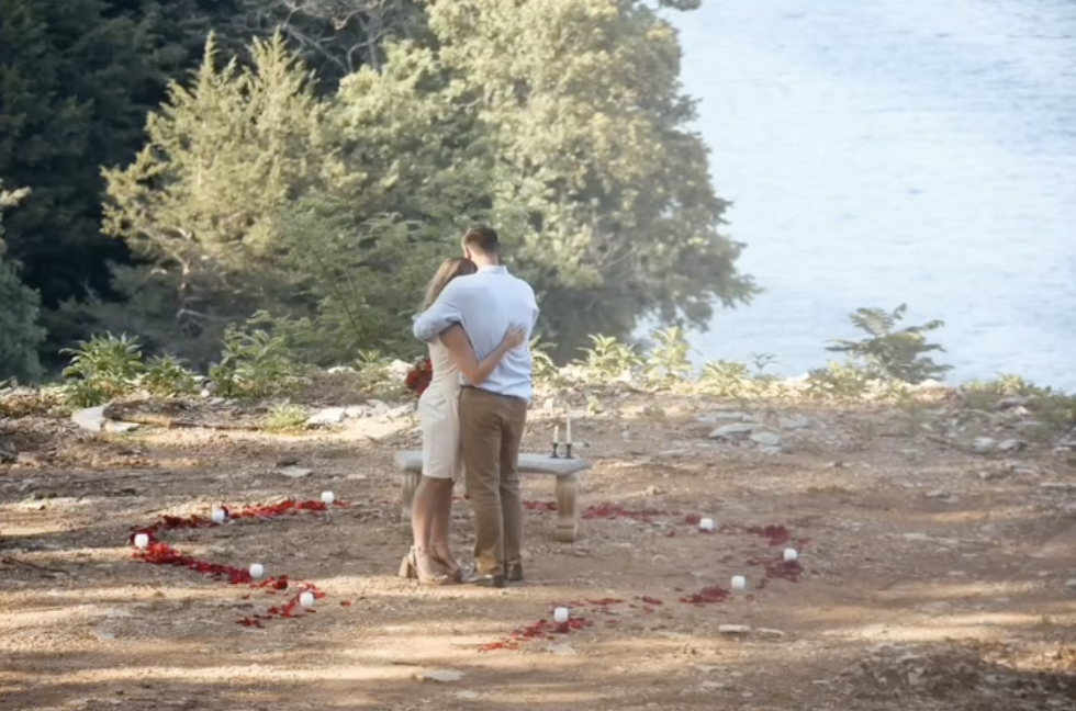 Jana Duggar and Stephen Wissmann embrace within the rose-petal heart, their backs to the camera as they share a quiet moment by the water's edge. | Source: Instagram/janamduggar