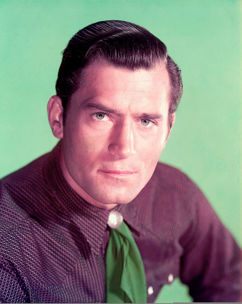 Studio portrait of US actor Clint Walker wearing a purple shirt and green tie circa 1960. | Photo: Getty Images