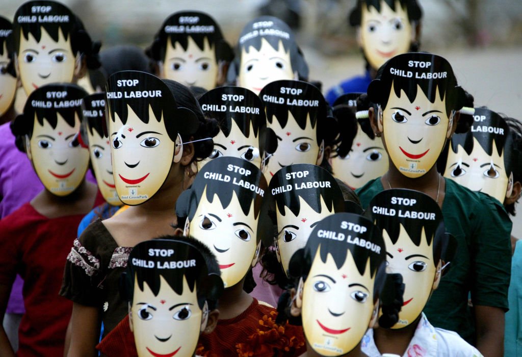 Indische Schulkinder tragen "Stopt die Kinderarebit"-Masken, als sie am 12. Juni 2008 an einem Aufklärungslauf in Hyderabad teilnehmen, um auf Kinderarbeit aufmerksam zu machen. Die Welt feiert den 12. Juni als Welttag gegen Kinderarbeit. (Foto crby Noah Seelam /AFP) I Quelle: Getty Images