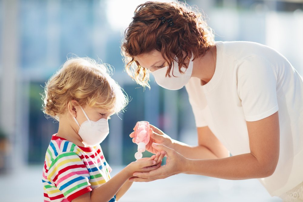 A child being given hand sanitizer while wearing a facemask during the coronavirus pandemic | Photo: Shutterstock/FamVeld