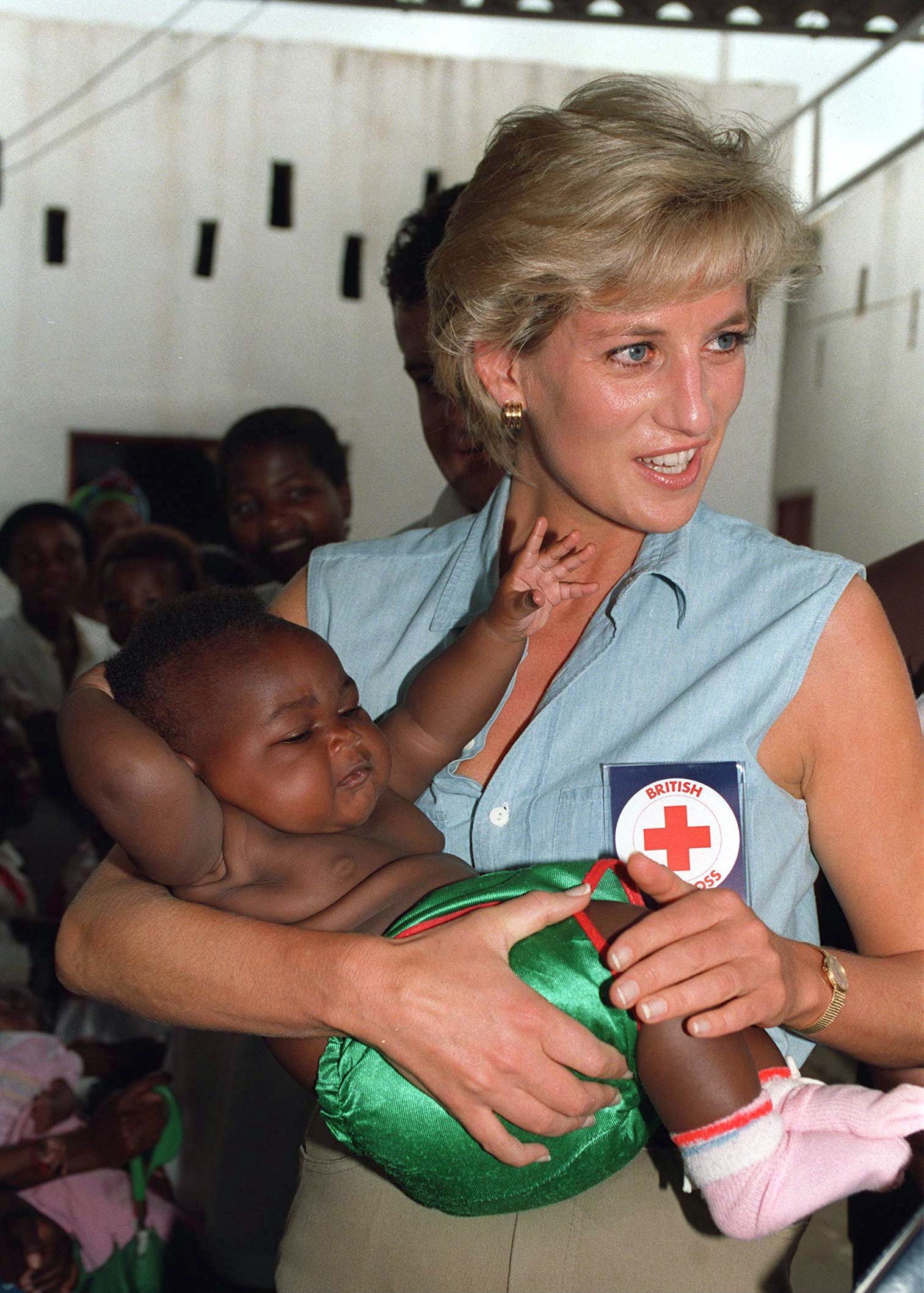 Princess Diana In Luanda, Angola. She Holds A Baby During Her Visit To A Orthopaedic Centre For Landmine Victims And Wears A Badge For The British Red Cross Charity on January 14, 1997. | Source: Getty Images