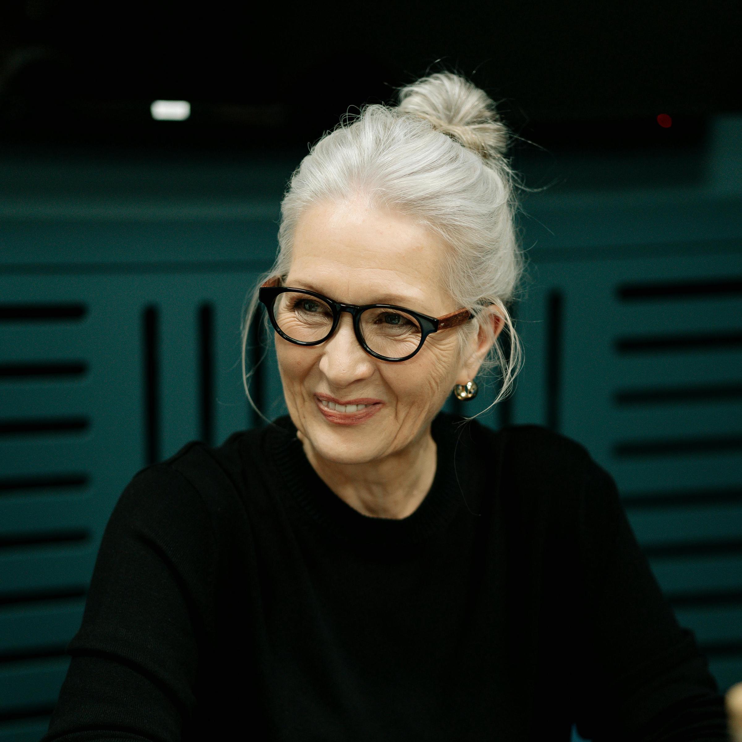 A whiter-haired woman smiling in conversation | Source: Pexels