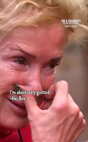 Fighting back tears, Beverley Callard attempts to compose herself as she admits she is "absolutely gutted", her expression reflecting both disappointment and heartbreak as her fellow campmates offer reassurance. | Source: Instagram/imacelebrity