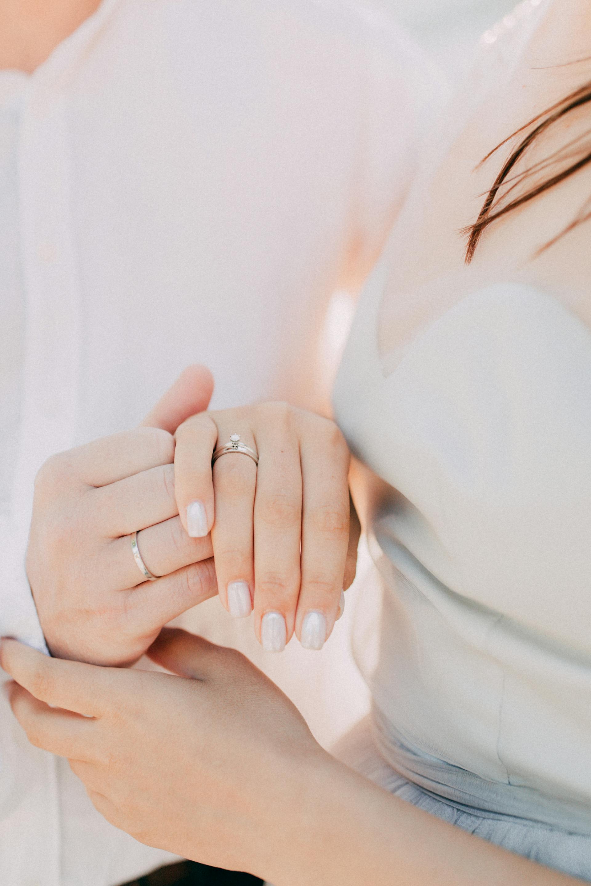 A closeup of a couple holding hands wearing wedding rings | Source: Pexels