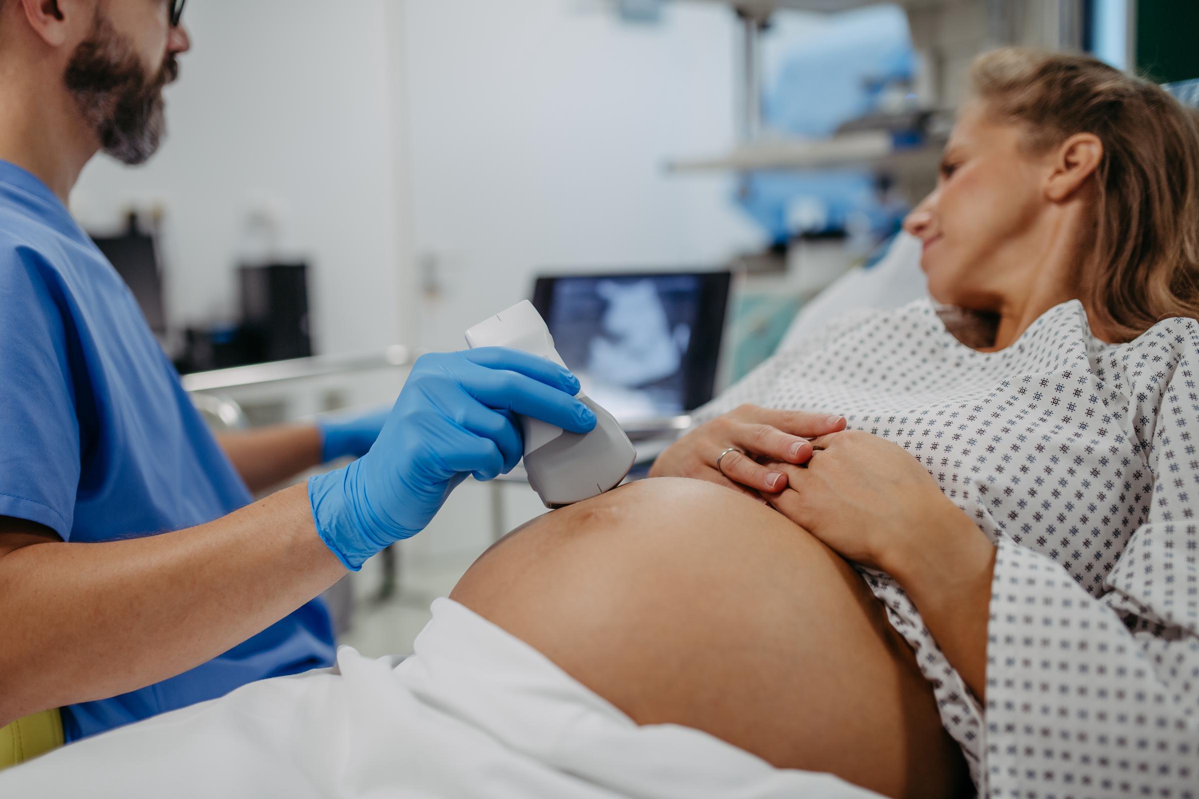 An Ob/gyn doctor performing an ultrasound of a baby on a pregnant woman | Source: Getty Images
