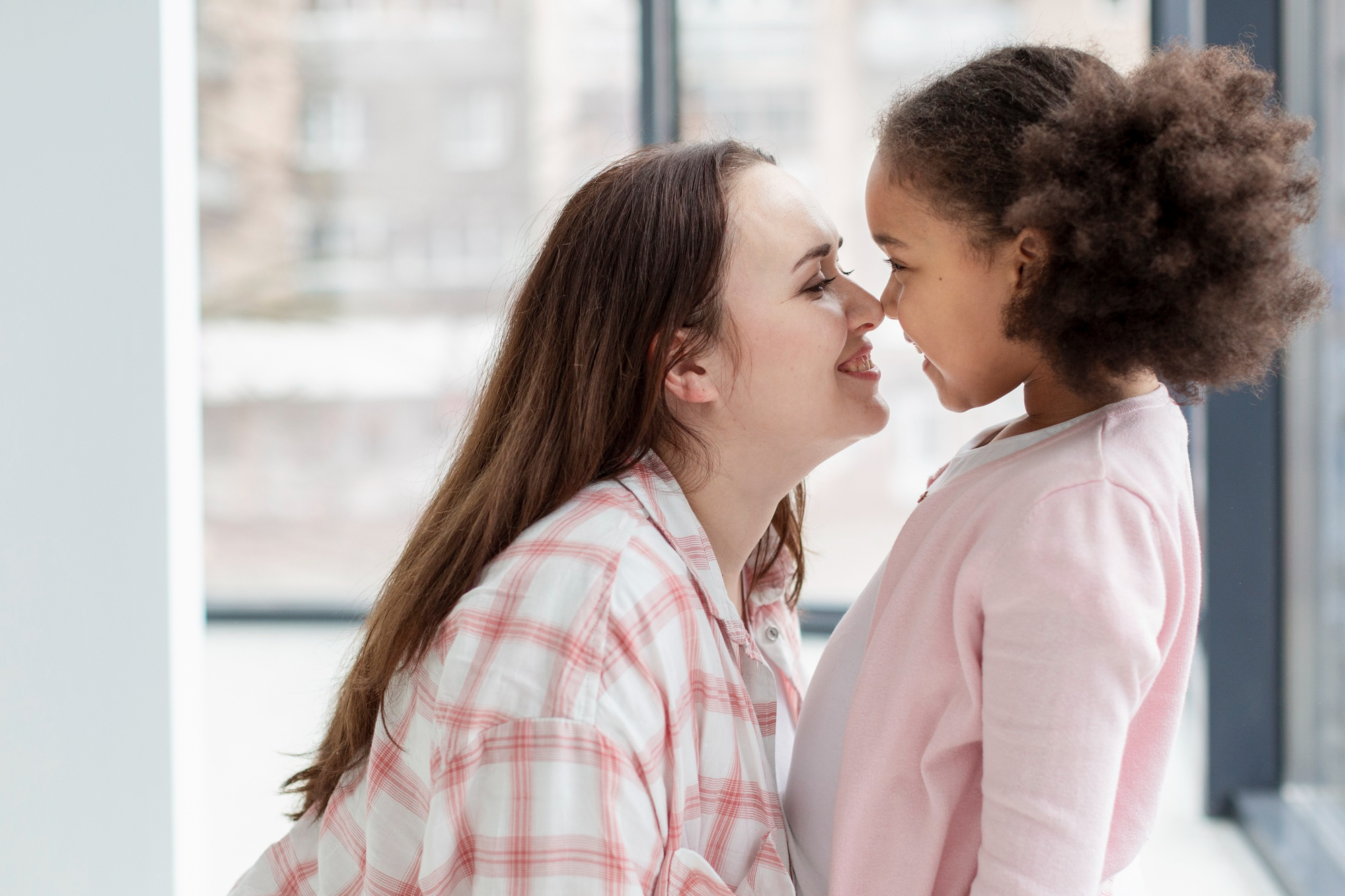 A mother rubbing her nose against her daughter's nose | Source: Freepik