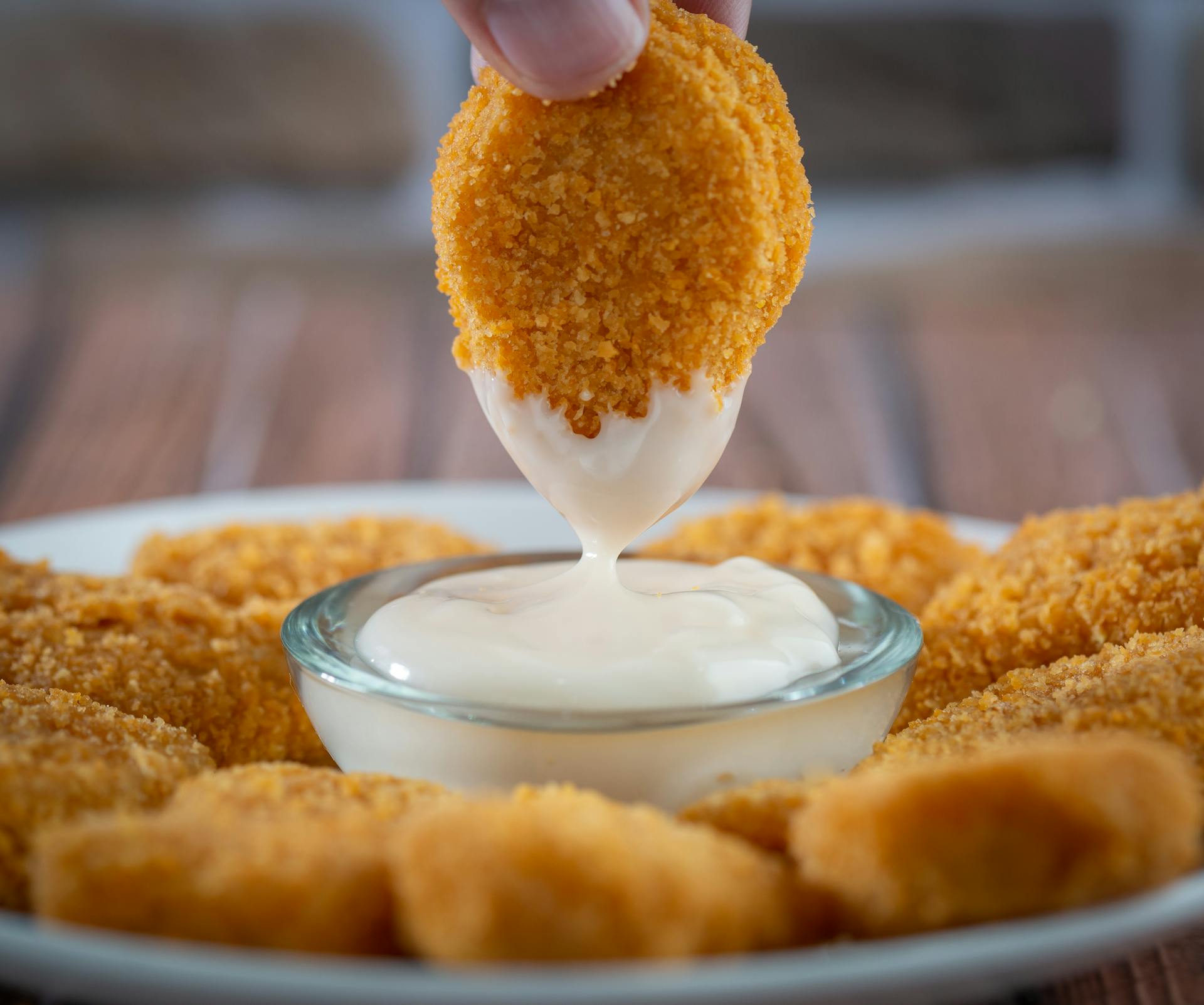 A person dipping a nugget in mayonnaise | Source: Pexels