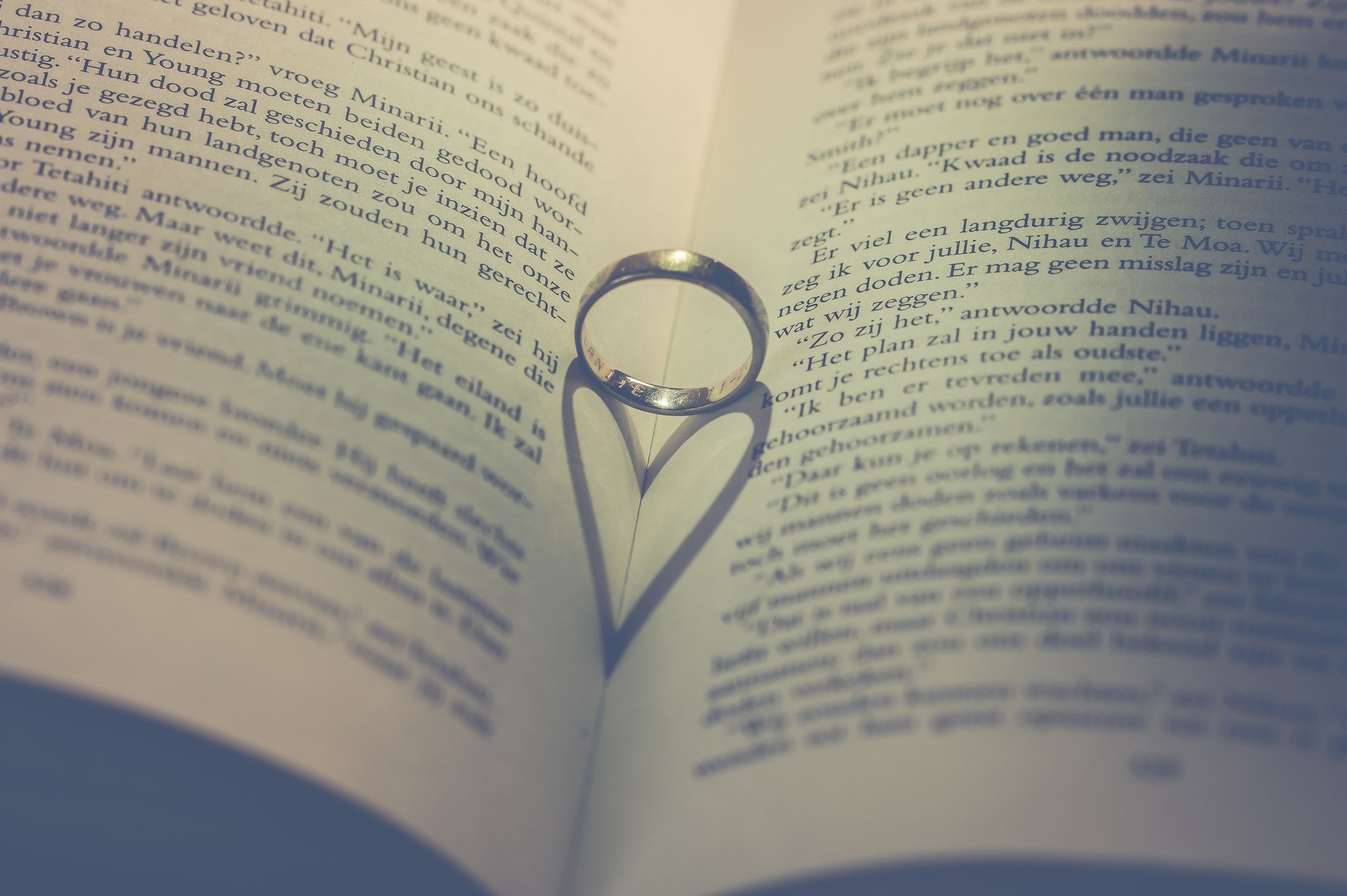 A wedding ring on an open book | Source: Pixabay