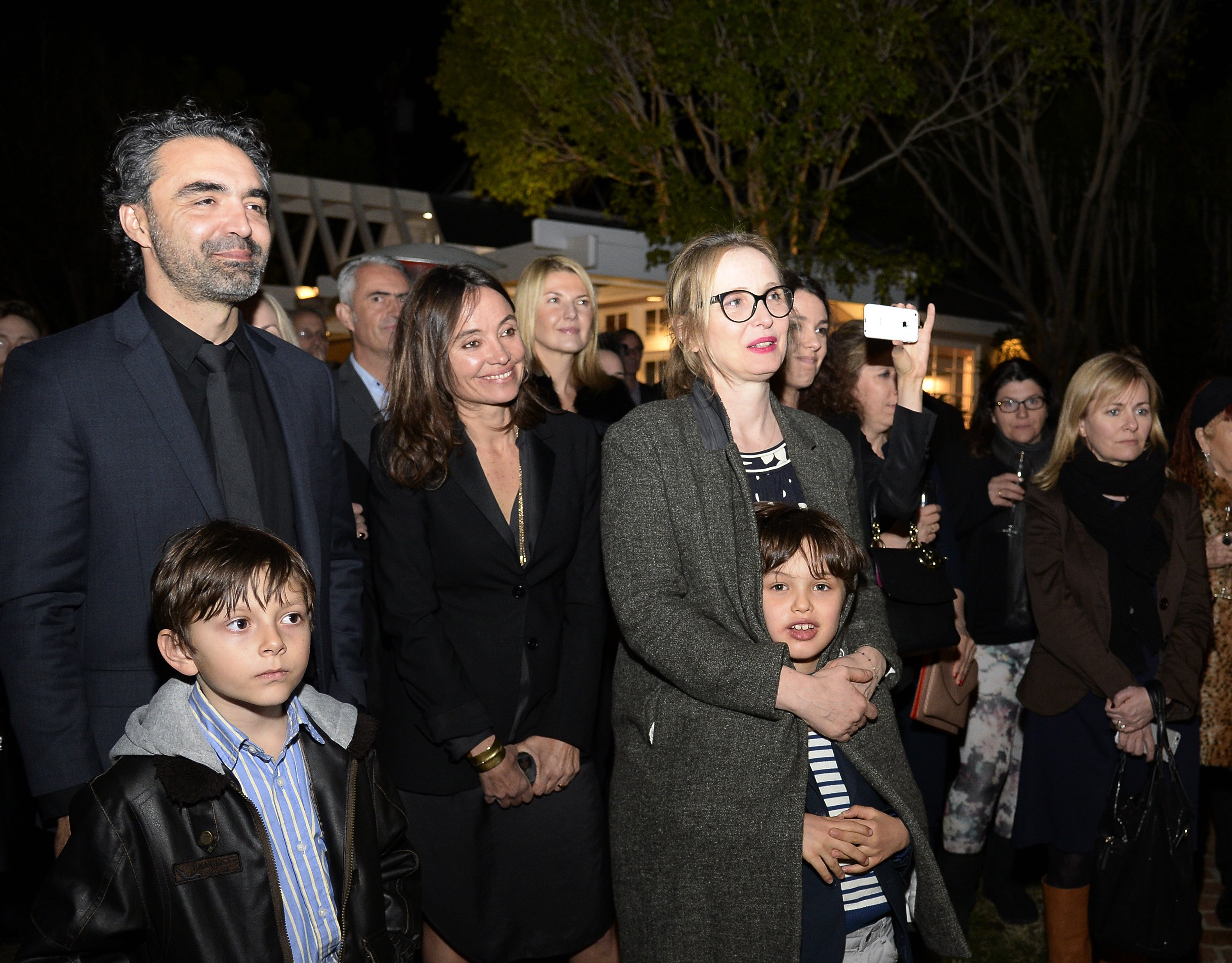  Actress Julie Deply (C) with her son Leo Streitenfeld and guests during a ceremony where she received the French Order of Arts and Letters from France's Culture Minister Mme Fleur Pellerin at La Residence de France on February 1, 2016, in Beverly Hills, California. | Source: Getty Images