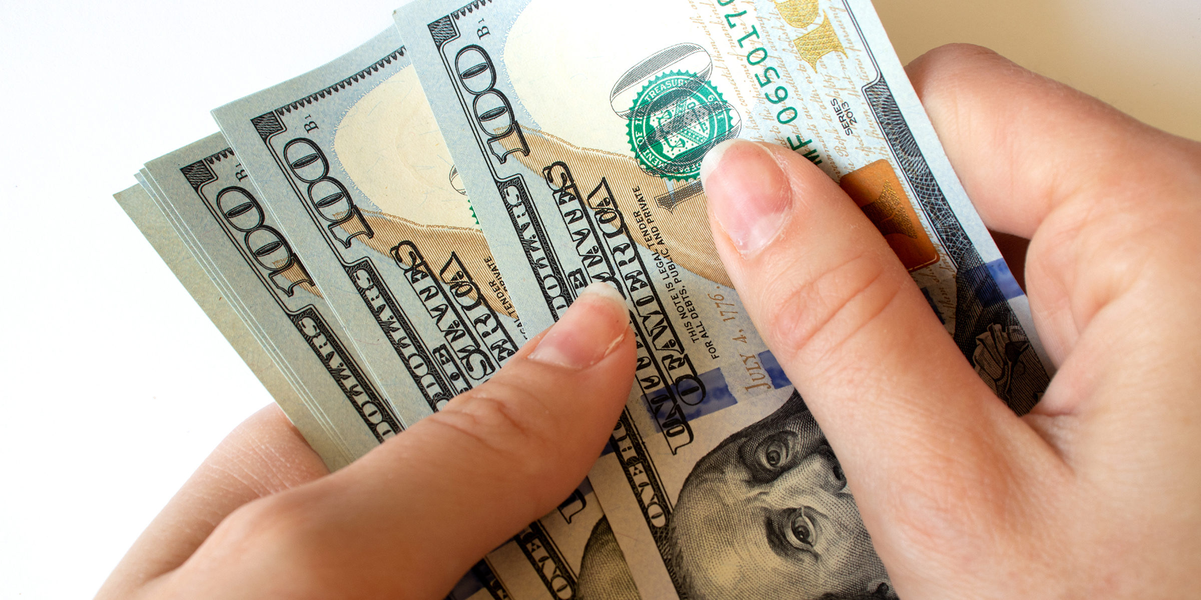 A person holding $100 bills | Source: Shutterstock
