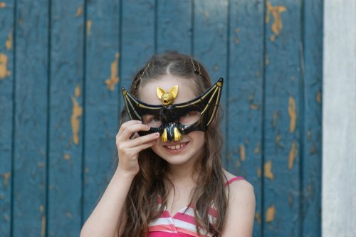 A young girl with a bat inspired Halloween mask. | Source: Shutterstock.