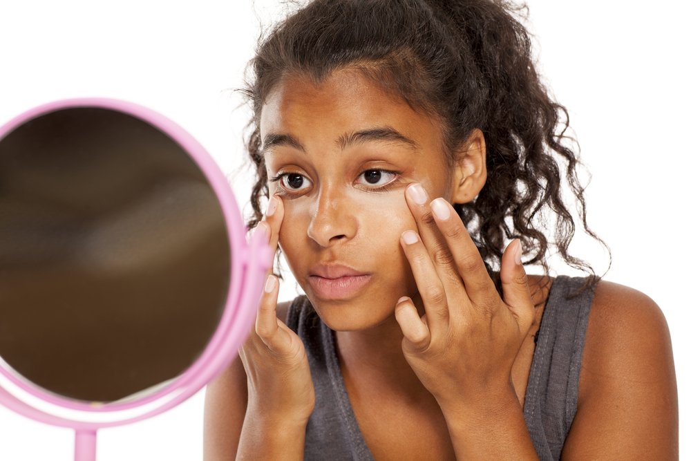 Modelo aplicándose corrector con los dedos. | Foto: Shutterstock