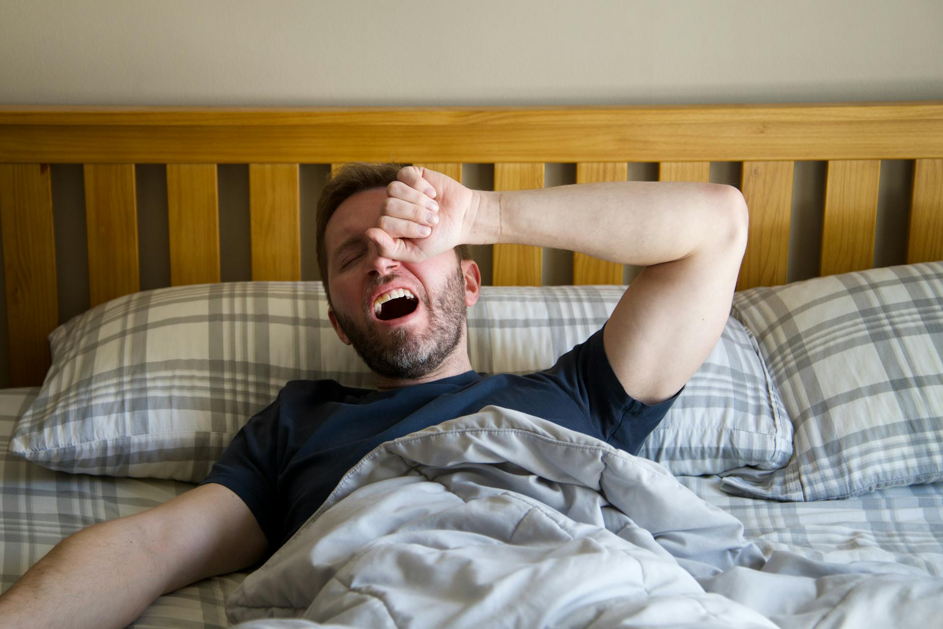 A man yawning and groggily rubbing his eyes | Source: Pexels