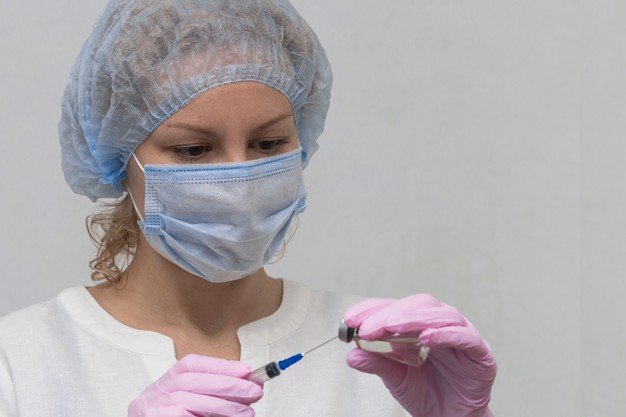 Un médecin tenant le vaccin anti-covid | photo : Freepik