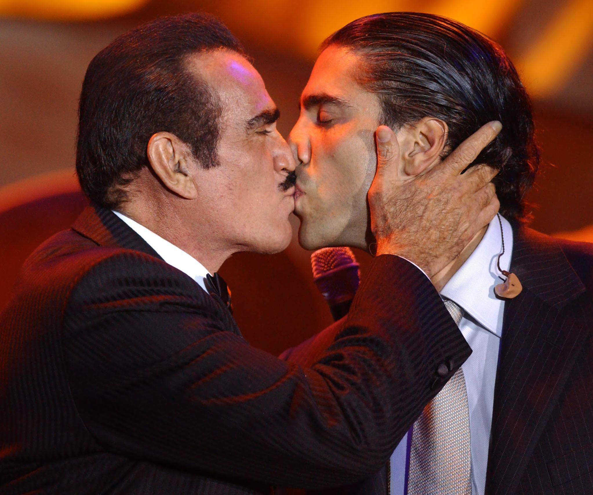 Vicente Fernandez (L) kisses his son, Alejandro Fernandez, after a duet at a tribute gala honoring him as the 2002 Latin Recording Academy (LARAS) Person of the Year, on September 17, 2002, in Hollywood, California. | Source: Getty Images