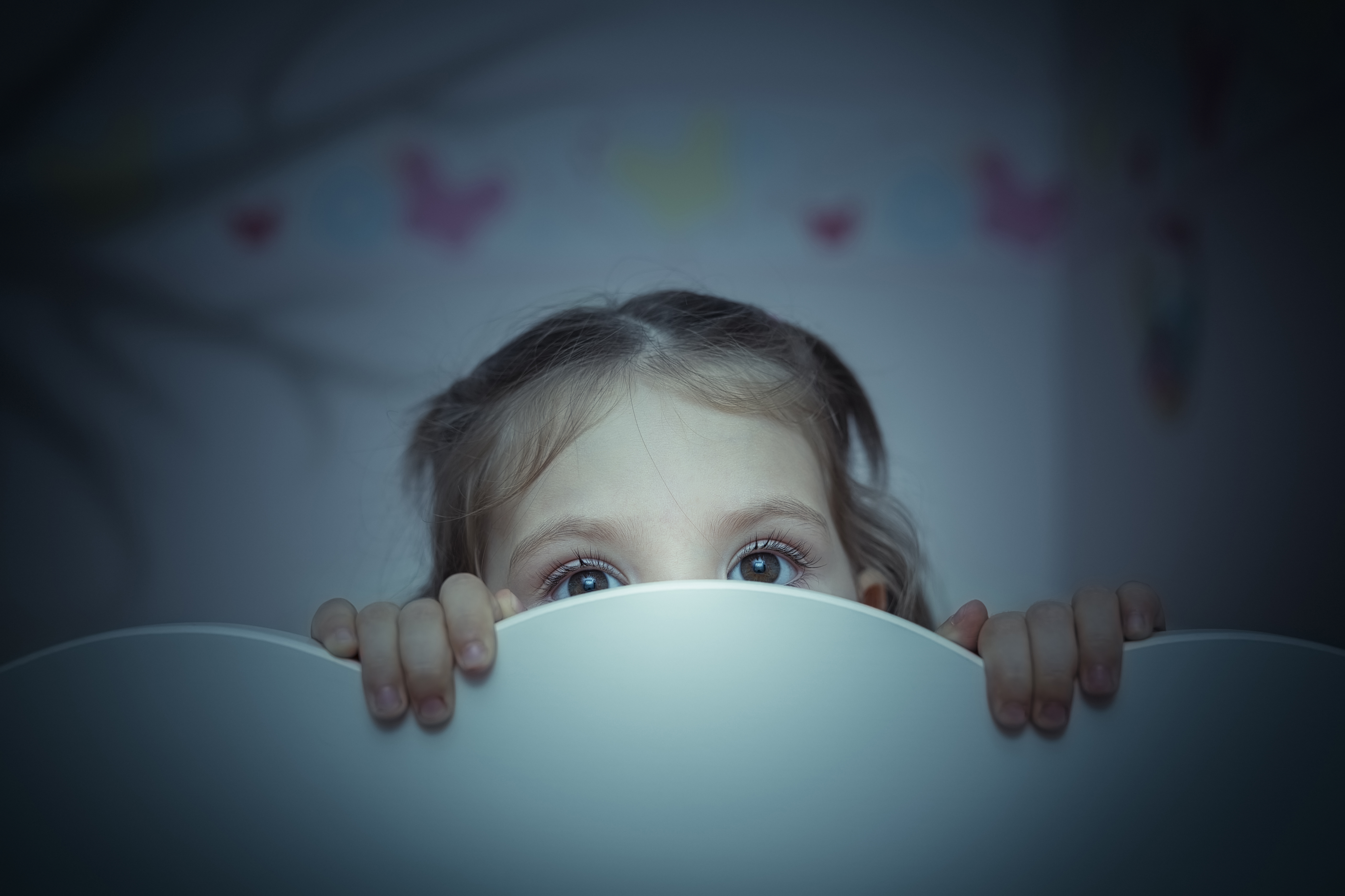 A little girl hiding behind a white surface | Source: Shutterstock