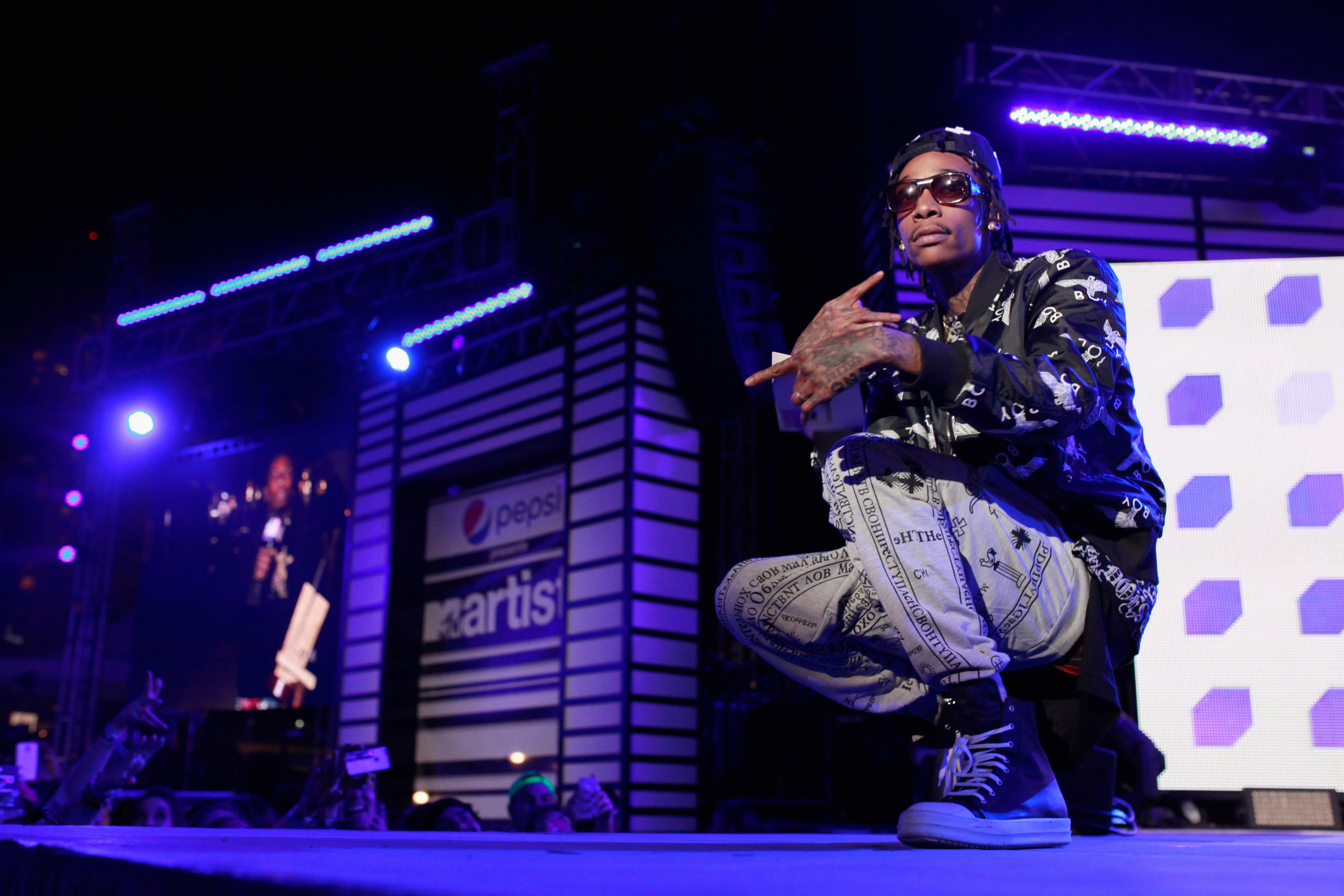 Wiz Khalifa onstage at the 2014 mtvU Woodie Awards and Festival wearing Converse sneakers on March 13 in Austin, Texas. | Source: Getty Images
