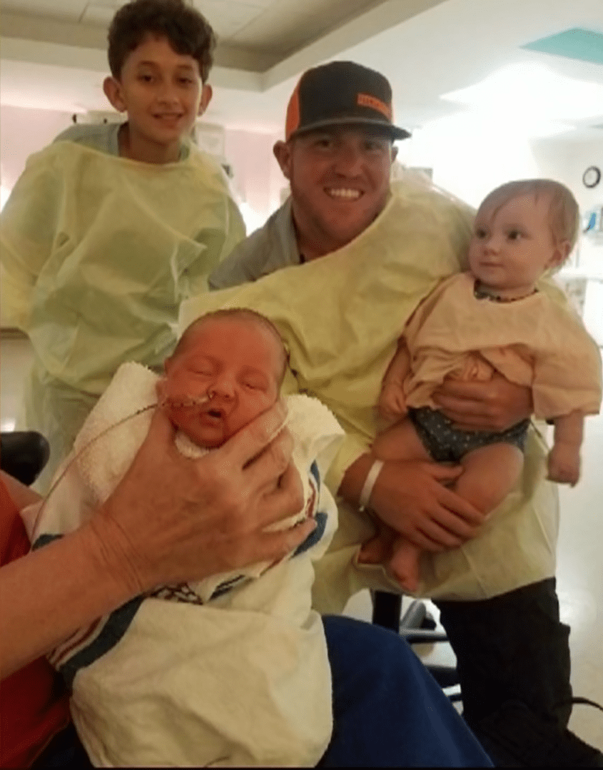 Kersey Richard carrying their toddler on his laps and Jayden Fontenot during their visit to the hospital to see the new born. | Source: Youtube.com/KPRC 2 Click2Houston