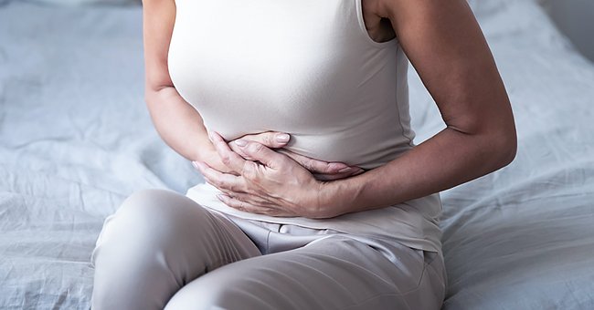 Une femme mal au ventre | Photo : Shutterstock
