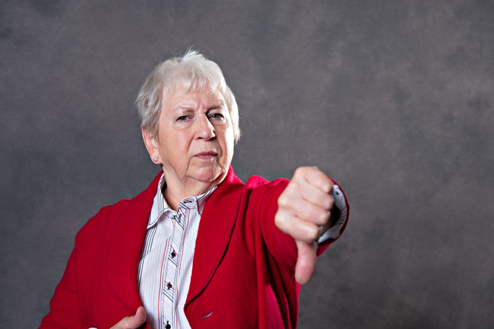 Mujer mayor enojada mostrando un pulgar hacia abajo. │Foto: Shutterstock