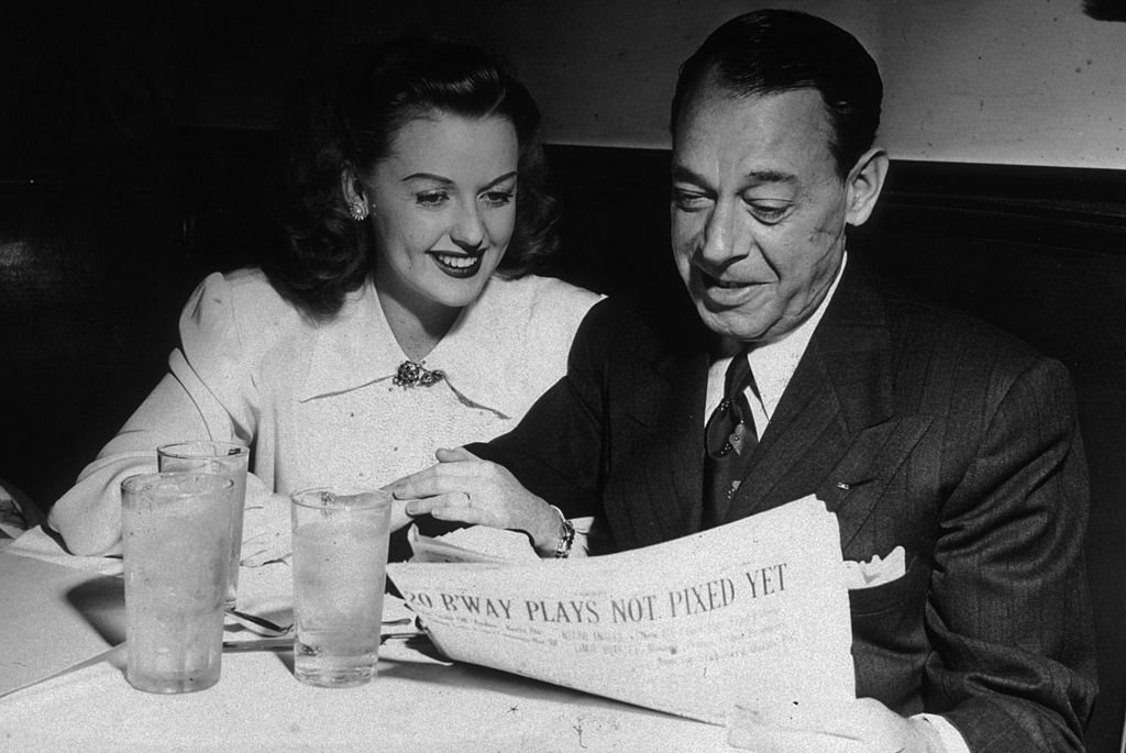 Joe E. Lewis  and Martha Stewart sitting side by side in a booth on January 01, 1946 | Photo: Getty Images