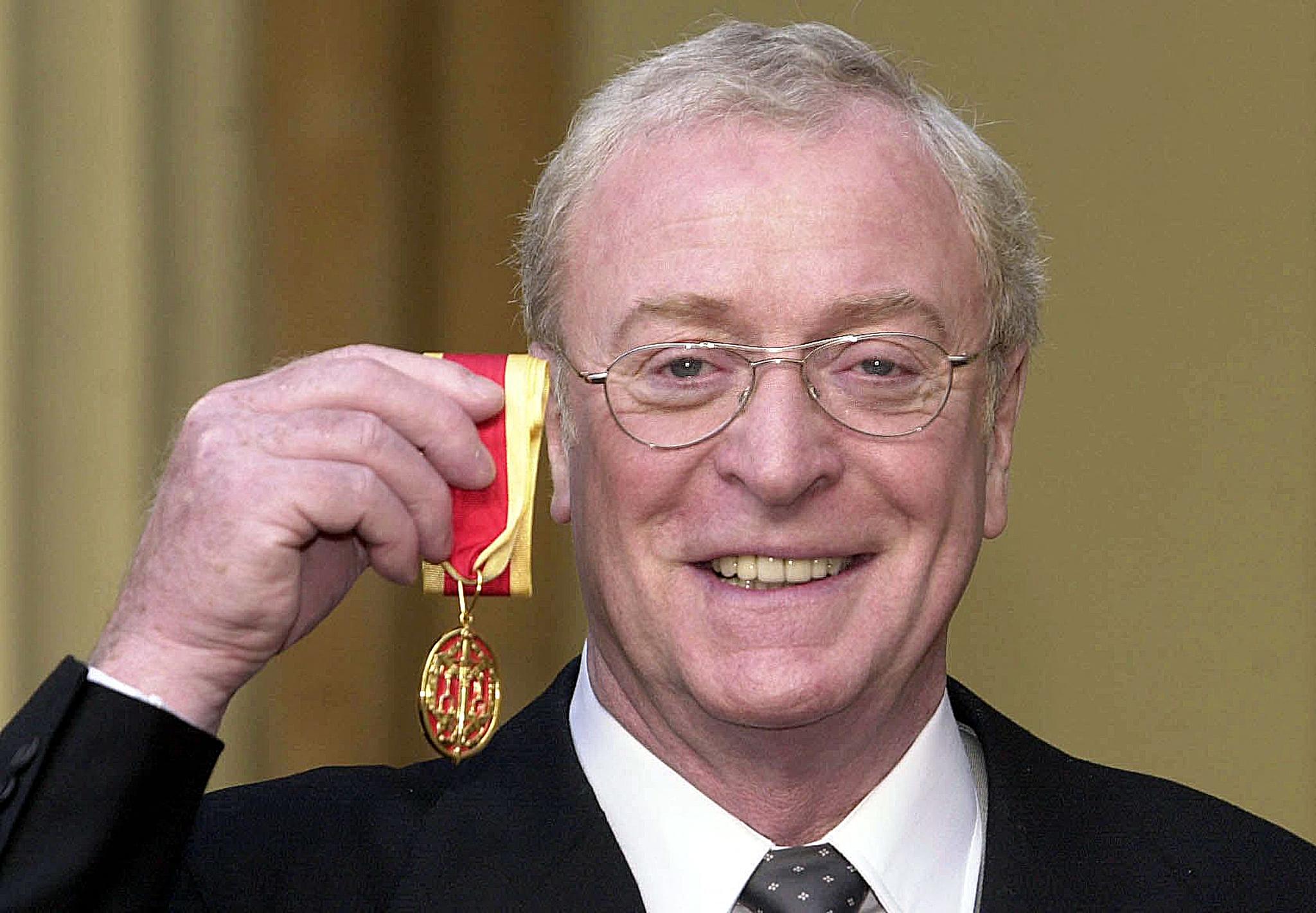 Michael Caine pictured displaying a knighthood he received from Britain's Queen Elizabeth II at Buckingham Palace on 16 November 2000 in London. / Source: Getty Images