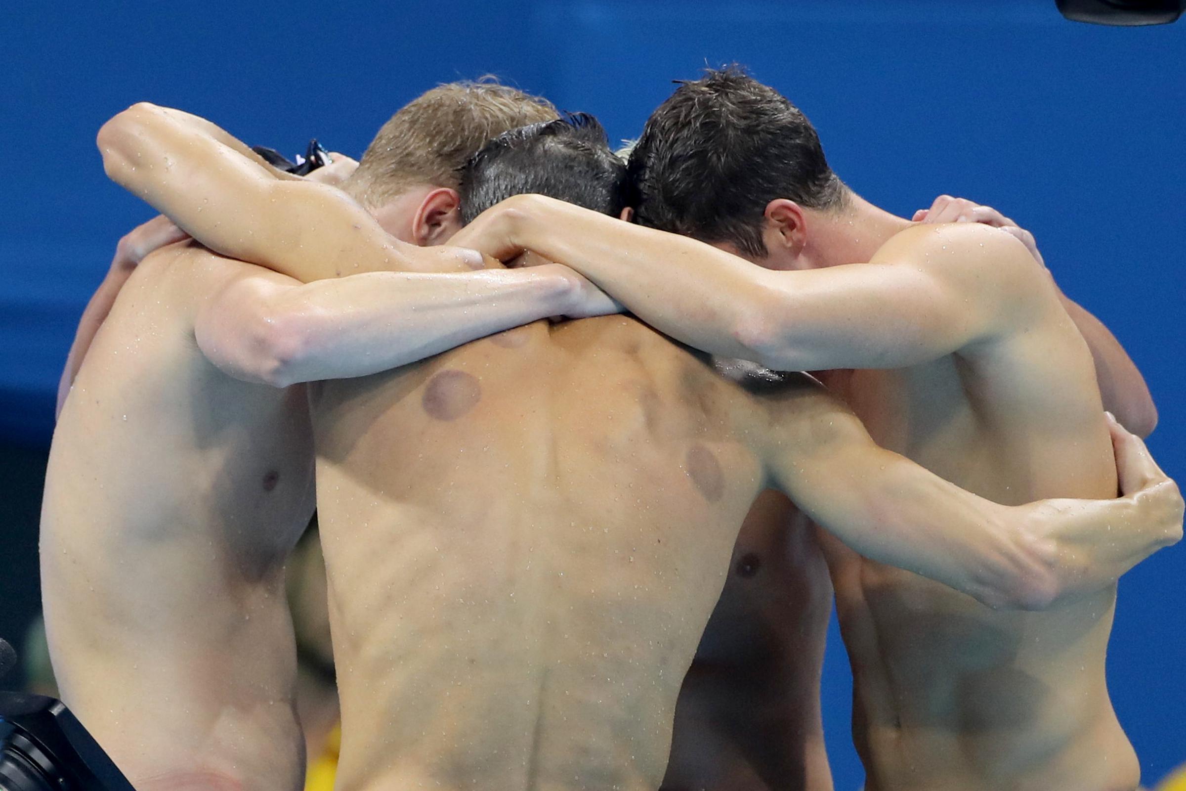 Conor Dwyer, Townley Hass, Ryan Lochte, and Michael Phelps embrace after winning the Mens 4 x 200m Freestyle Relay Final in Rio de Janeiro, Brazil, on August 9, 2016. | Source: Getty Images