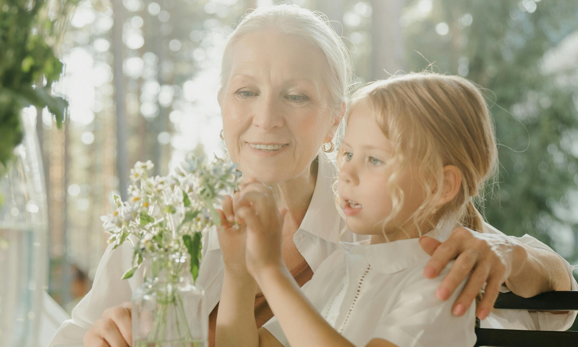 An elderly woman and child arrange flowers together | Source: Pexels