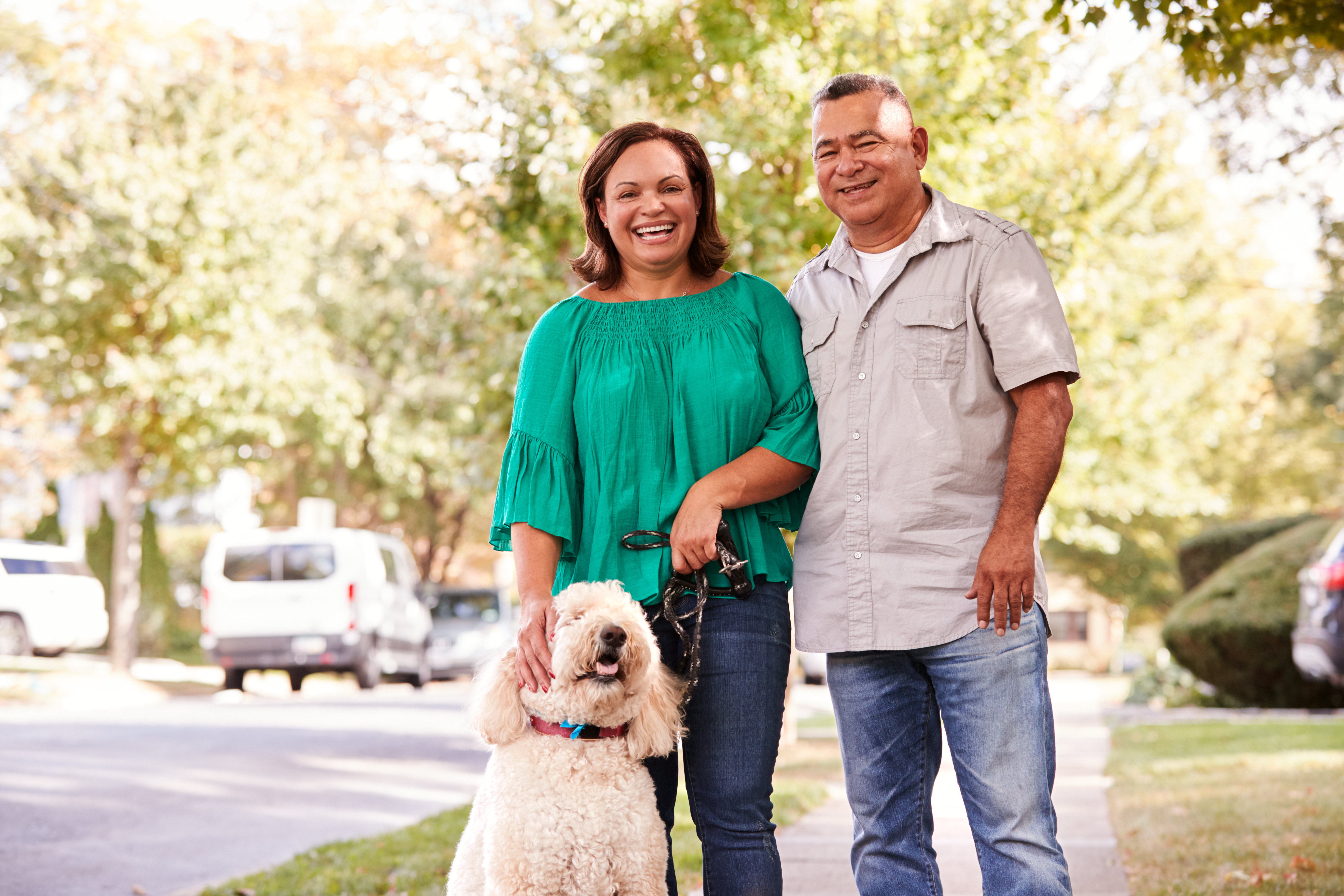 A senior couple standing with their dog in a street | Source: Shutterstock