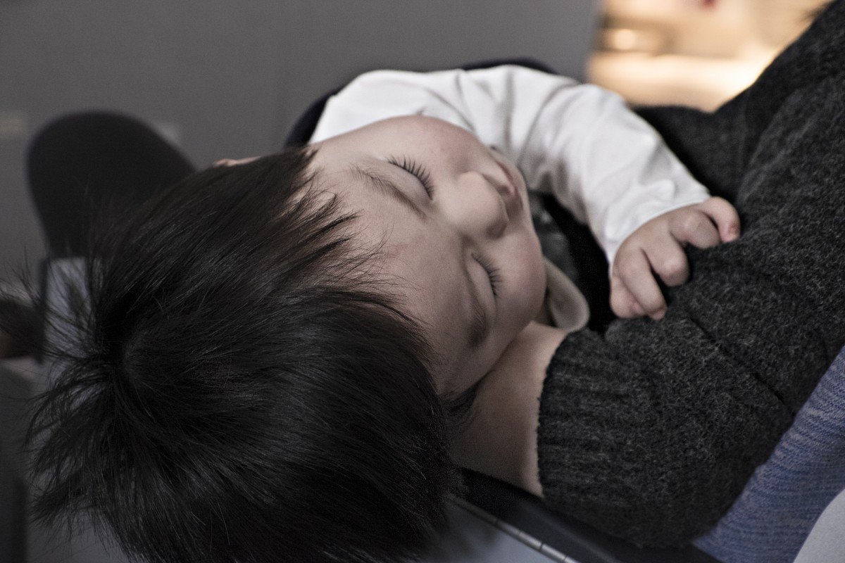 Un bébé dans les bras d'un adulte. l Source: PxHere Un bébé dans les bras d'un adulte. l Source: PxHere