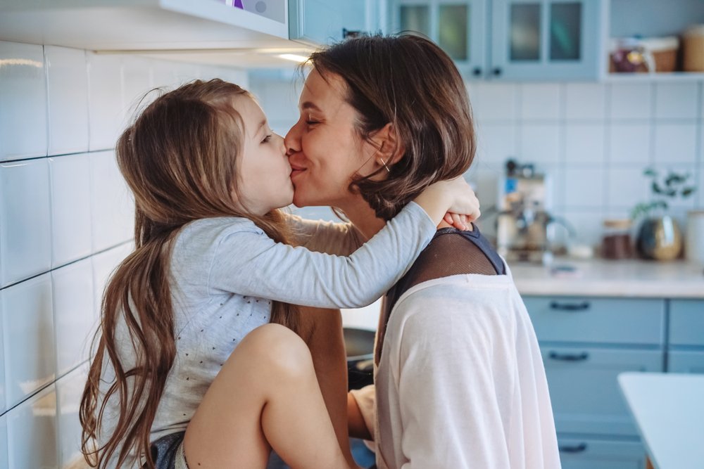 Madre e hija compartiendo un beso. | Foto: Shutterstock