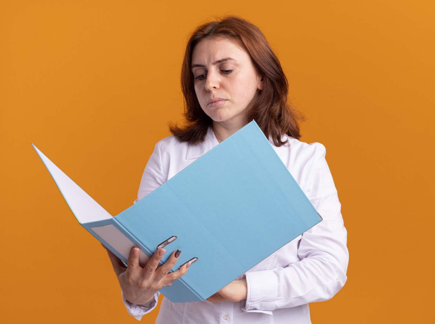 A woman with a serious expression holding a folder | Source: Freepik