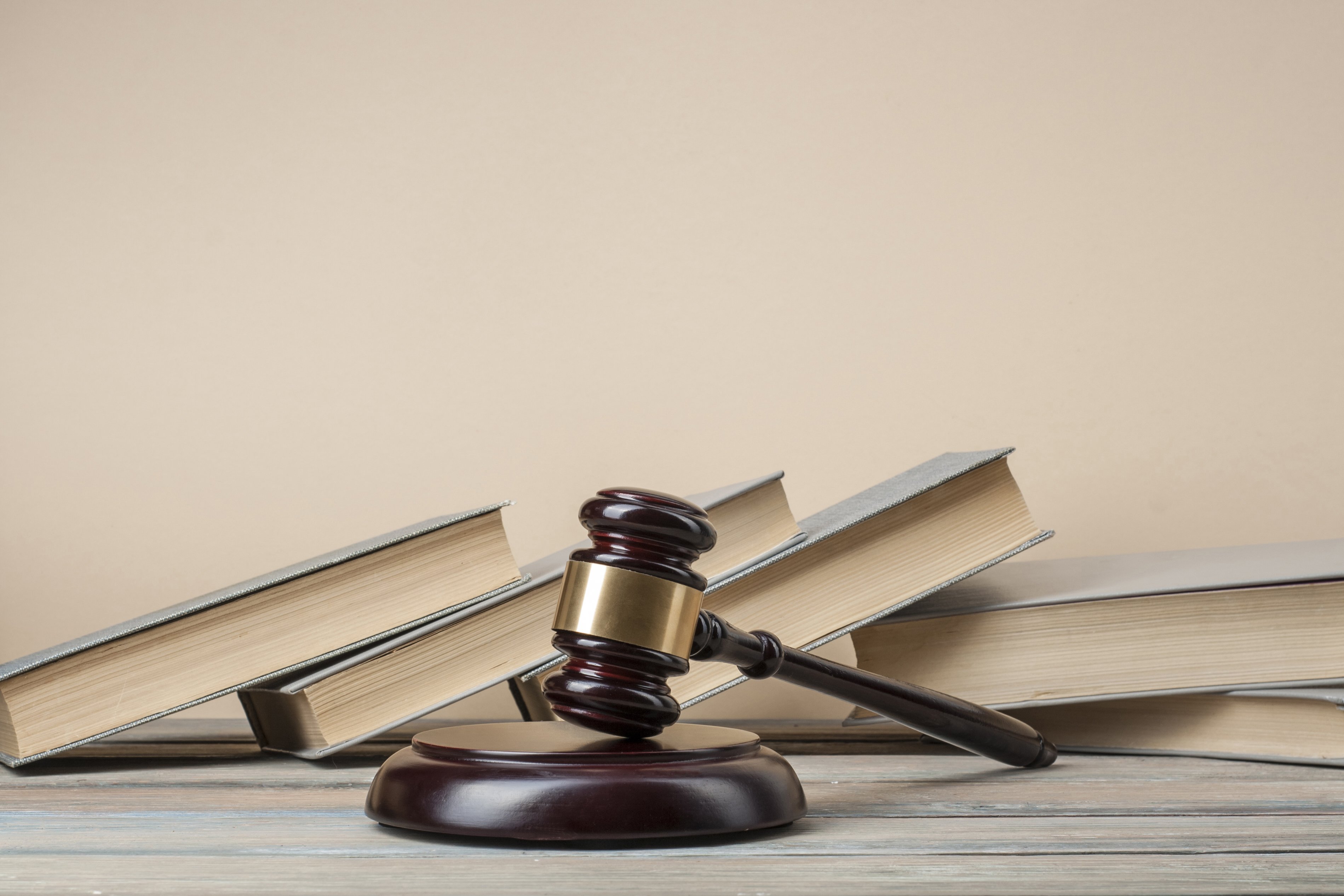 Livres avec des juges en bois gavés sur table dans une salle d'audience. | Photo : Shutterstock