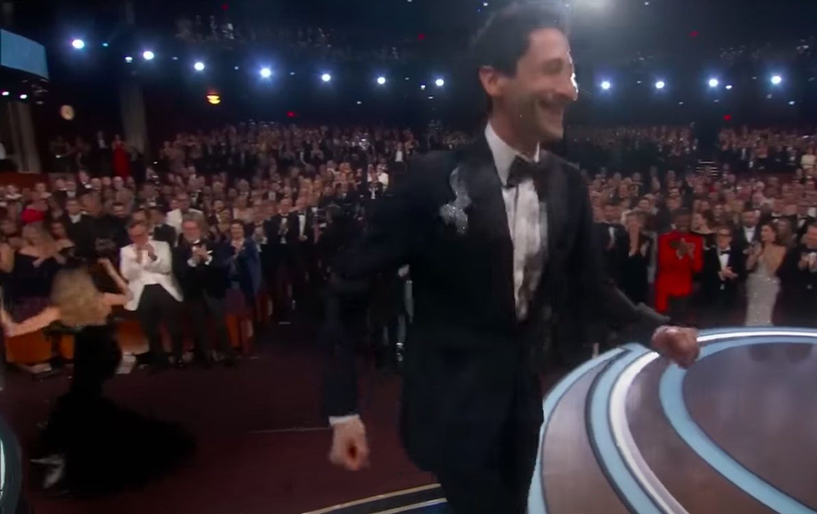 Georgina Chapman trying to locate the piece of gum as Adrien Brody makes his way to the stage to accept his award, posted on March 3, 2025. | Source: YouTube/ABC News