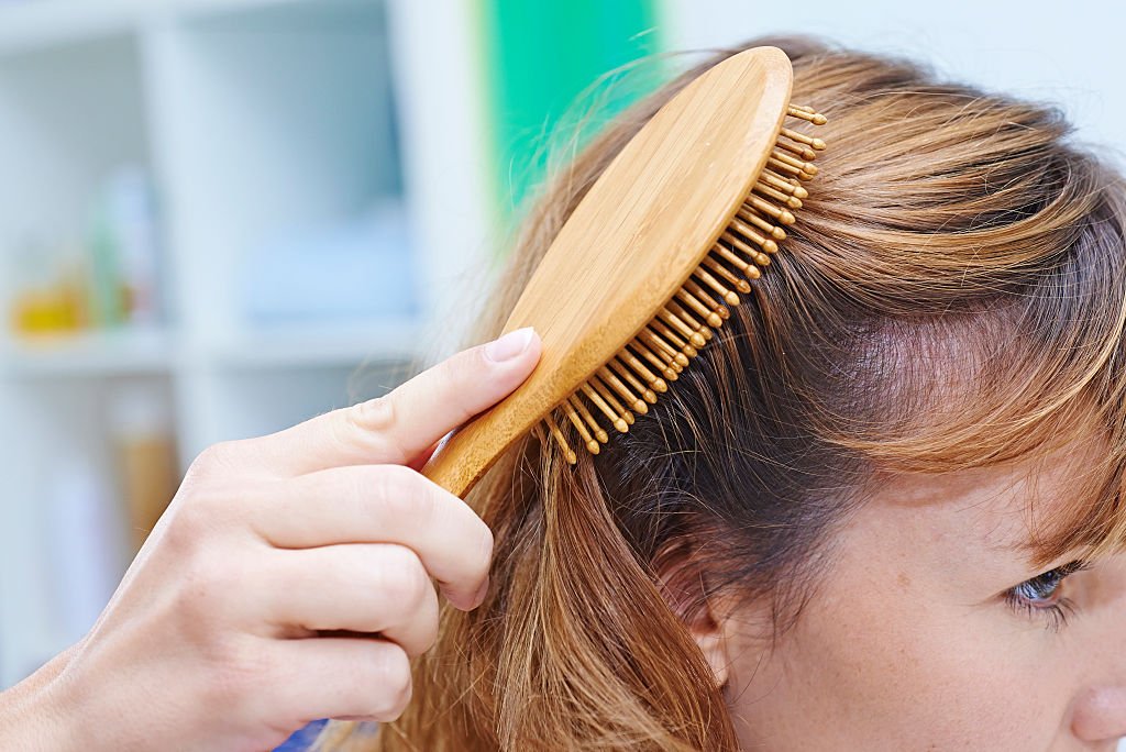 Une femme qui brosse ses cheveux. | Photo : Getty Images