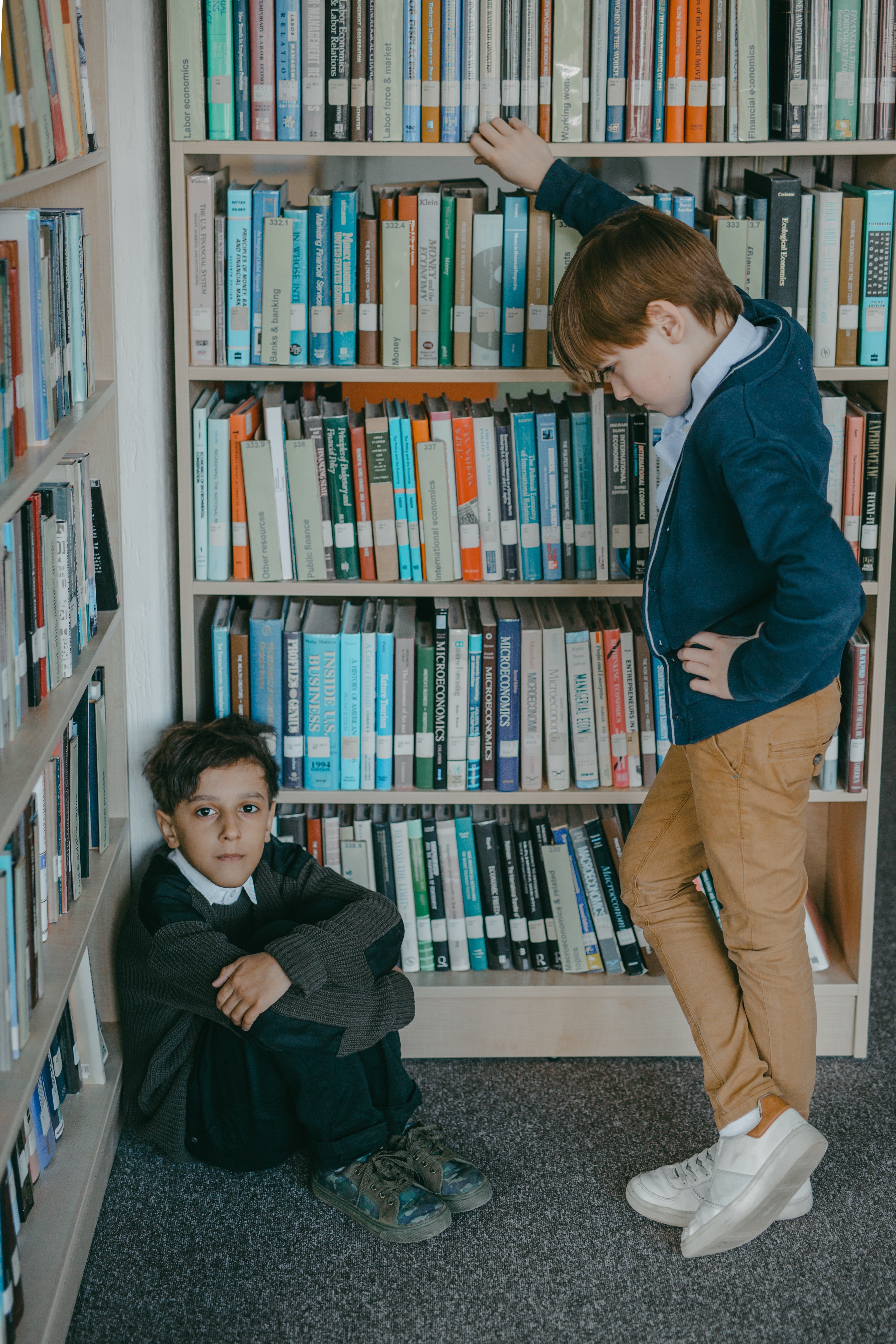 Niños en un pasillo de una biblioteca. | Foto: Pexels