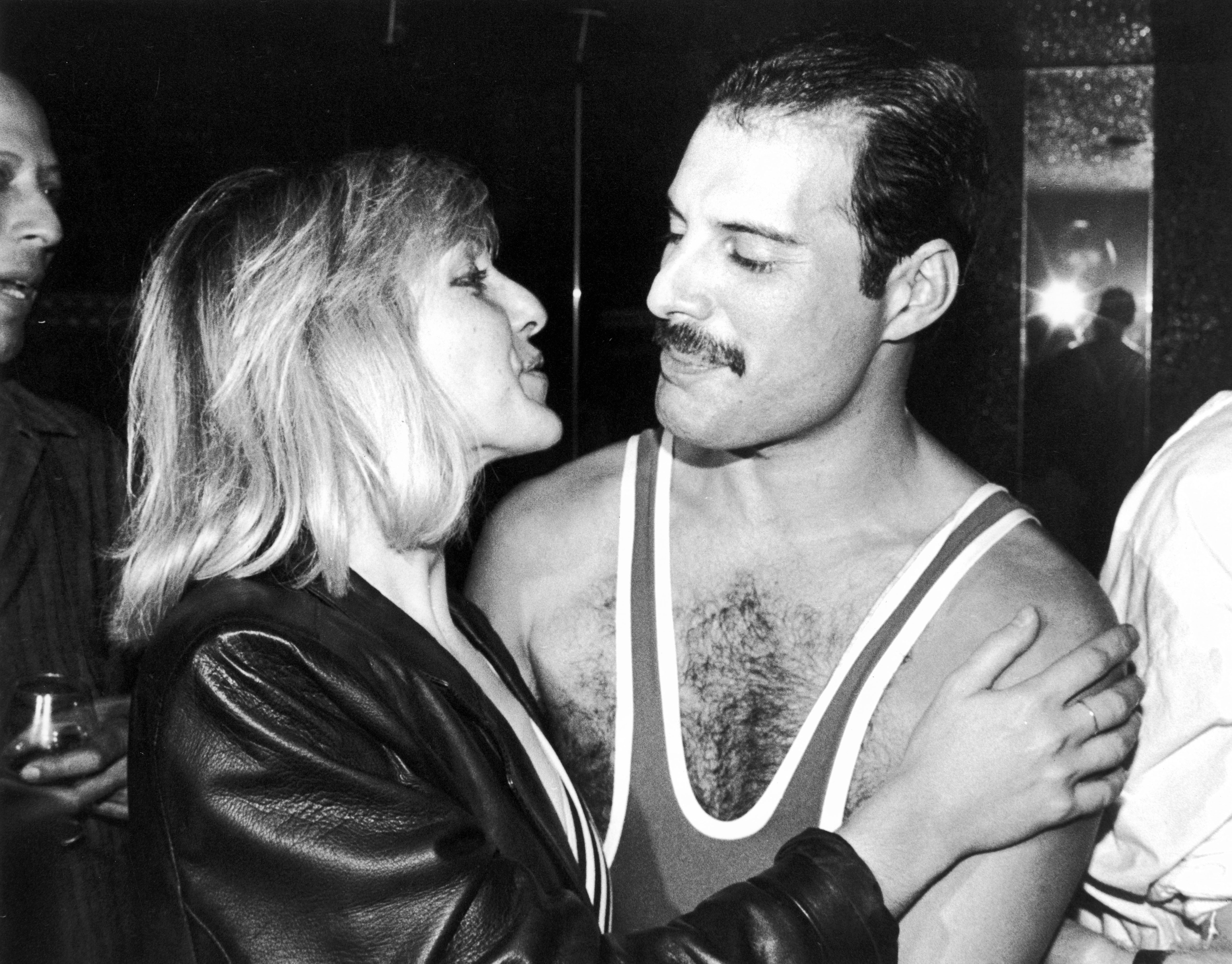Mary Austin und Freddie Mercury teilen einen zärtlichen Moment hinter der Bühne vor einem Queen-Auftritt in London, 1984 | Quelle: Getty Images