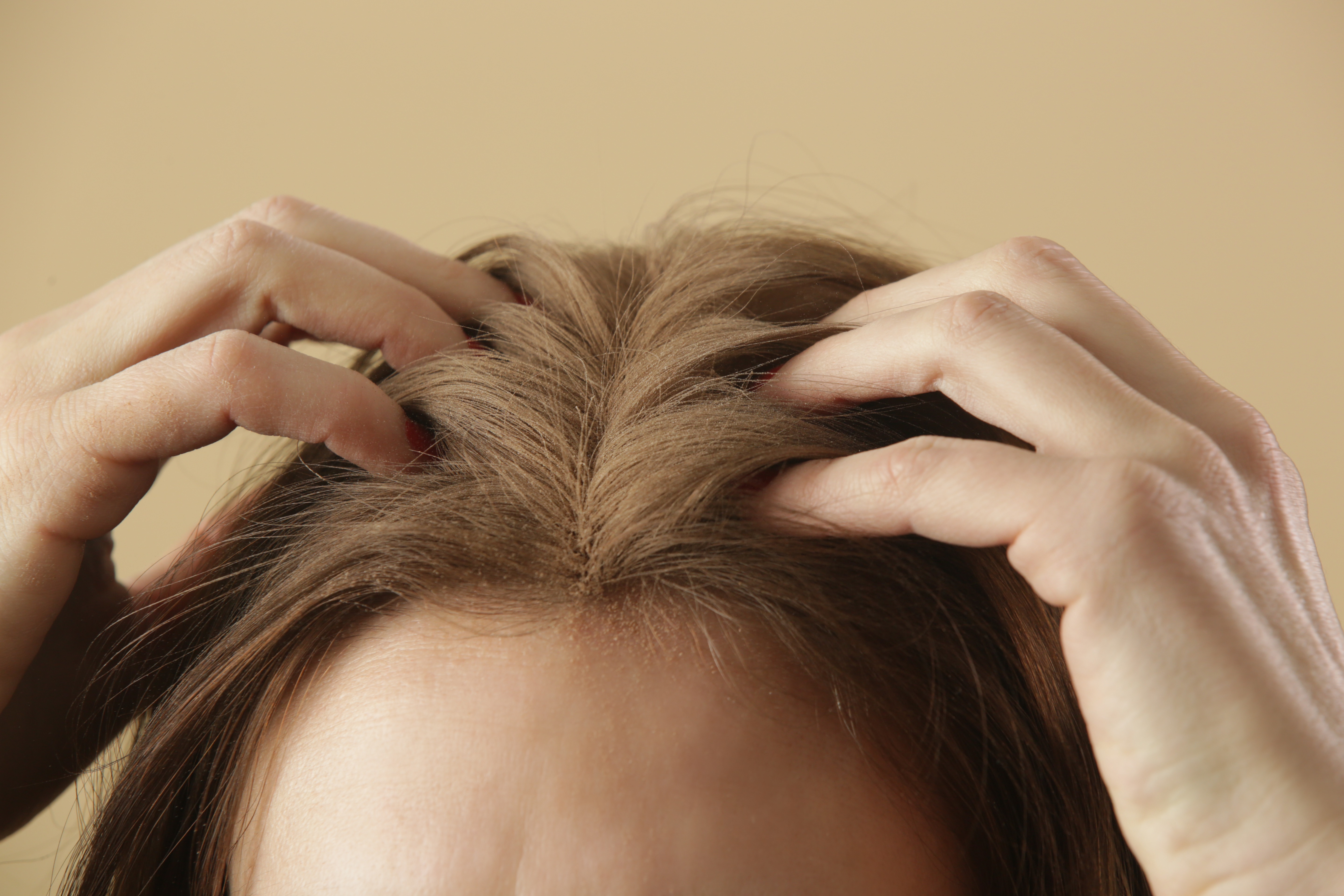 Photo of a woman massaging dry shampoo into her scalp | Source: Getty Images